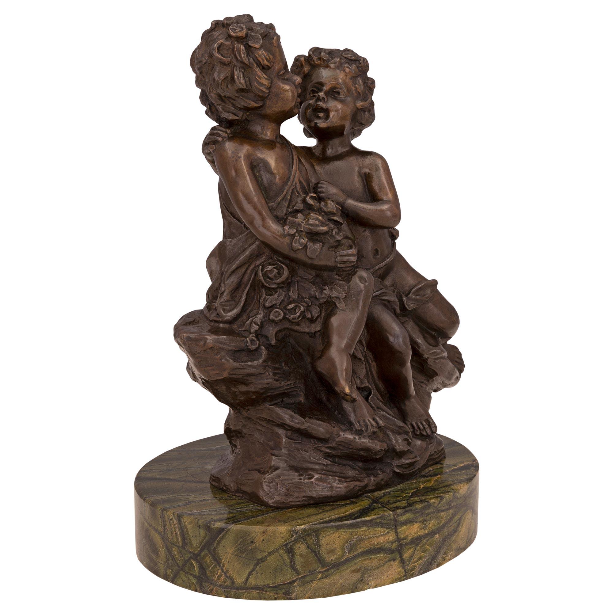 A charming French 19th century Louis XVI st. patinated bronze and marble statue, signed Auguste Moreau. The statue is raised by a fine circular marble base. The bronze above depicts a lovely scene of a young boy courting a charming young girl. They