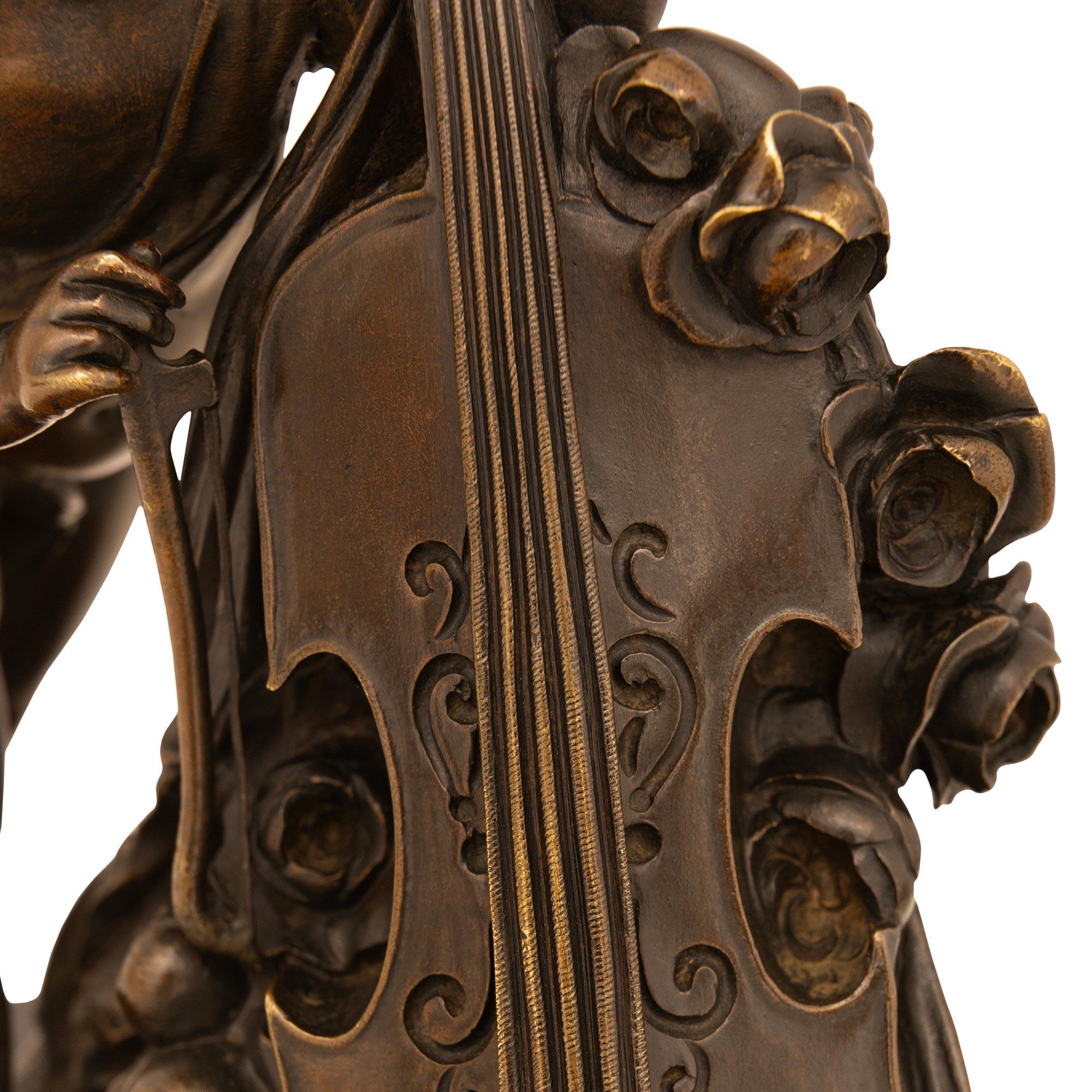 Charmante statue d'angelot en bronze patiné et marbre noir belge de style Louis XVI du XIXe siècle. Cette charmante statue est surélevée par une base rectangulaire en marbre belge noir avec un bord lisse et poli. La base en marbre est surmontée d'un