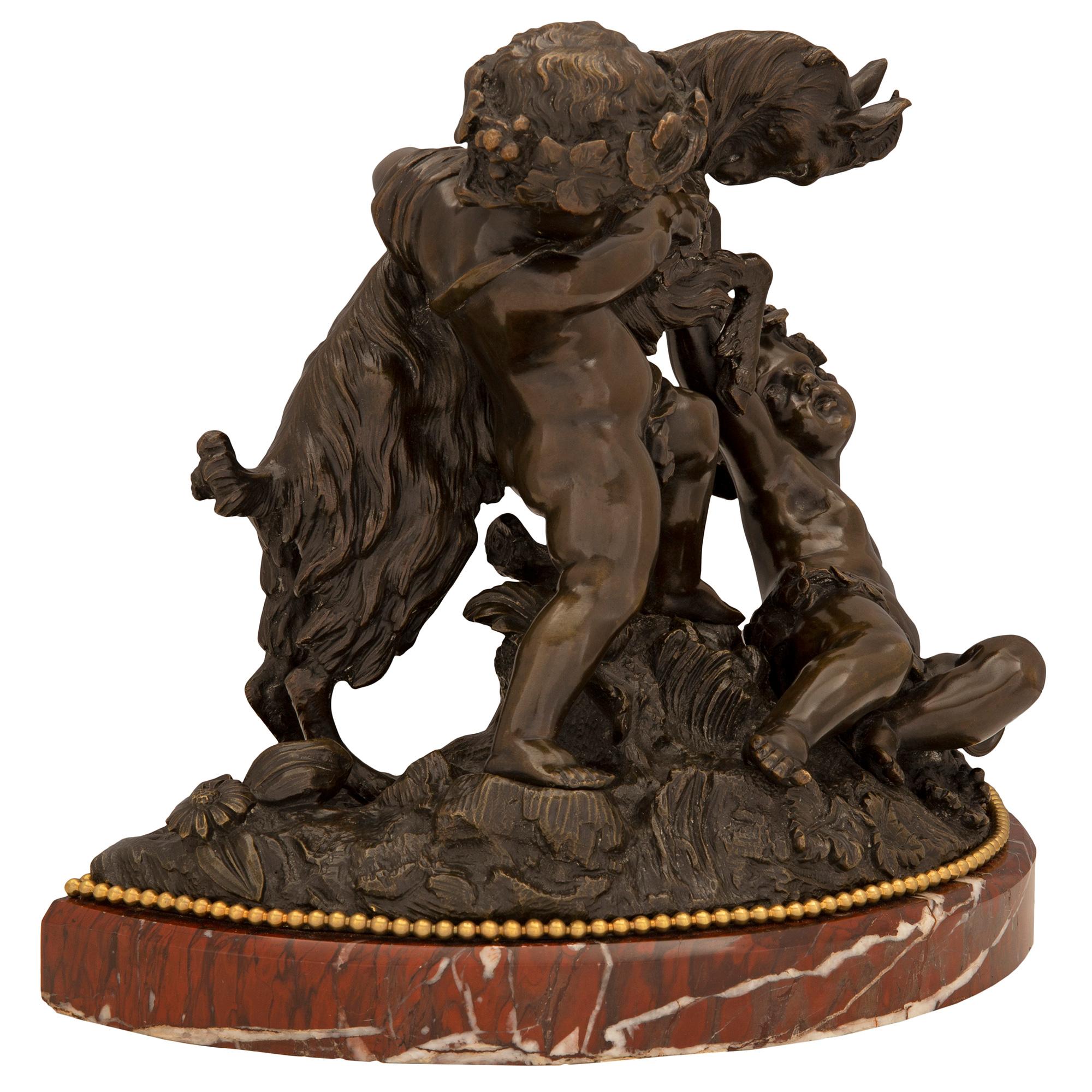 Una sensazionale statua francese del XIX secolo in bronzo patinato, ormolu e marmo Rouge Griotte, firmata Clodion. La statua è sollevata da una base in marmo Rouge Griotte modellata a forma di demi lune con una raffinata fascia in ormolu. Sopra ci