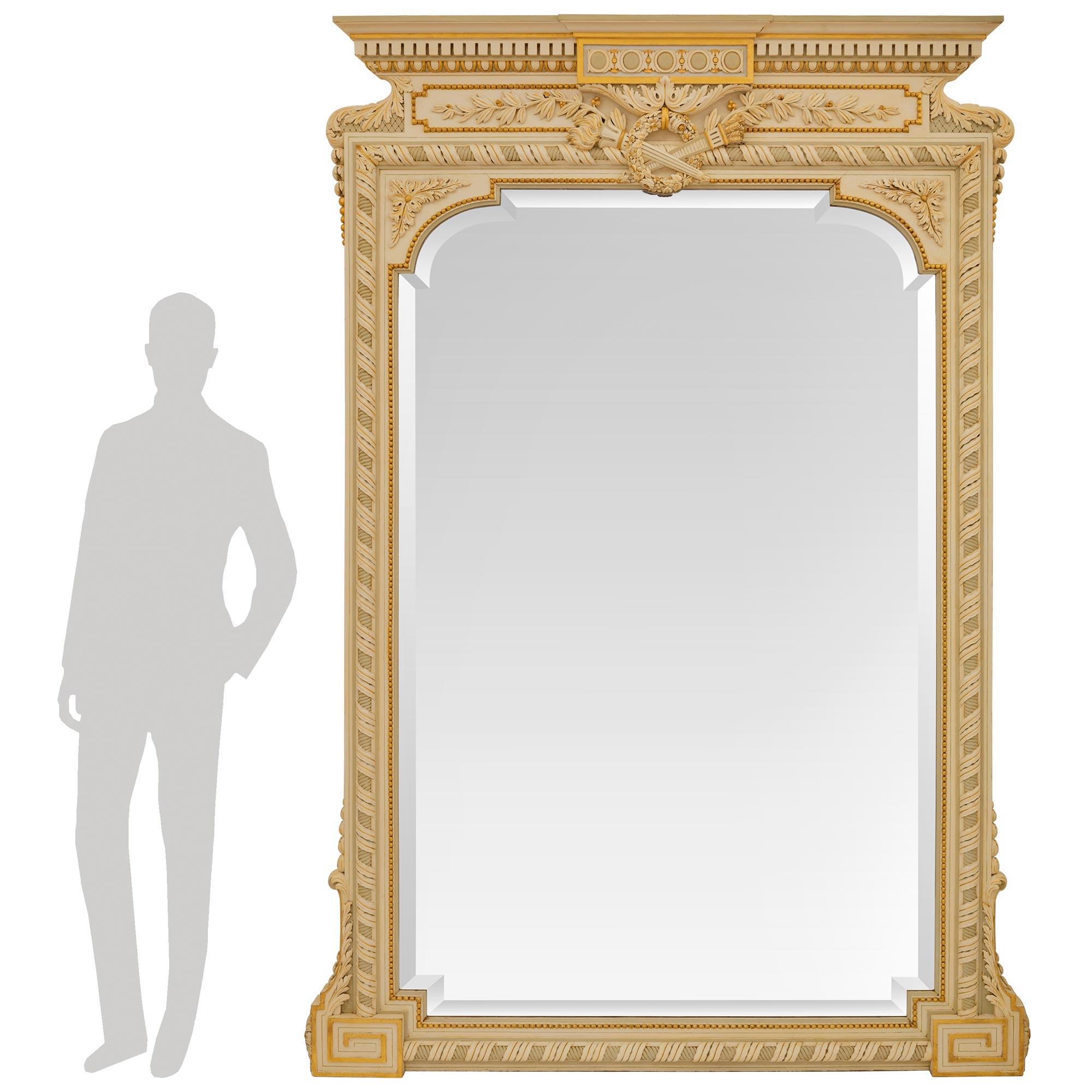 A large scale and most impressive French 19th century Louis XVI st. patinated Wood and Giltwood mirror. The original beveled mirror plate is set within a fine Giltwood beaded and a ribbon border with a twisted rope on all four sides. The bottom two
