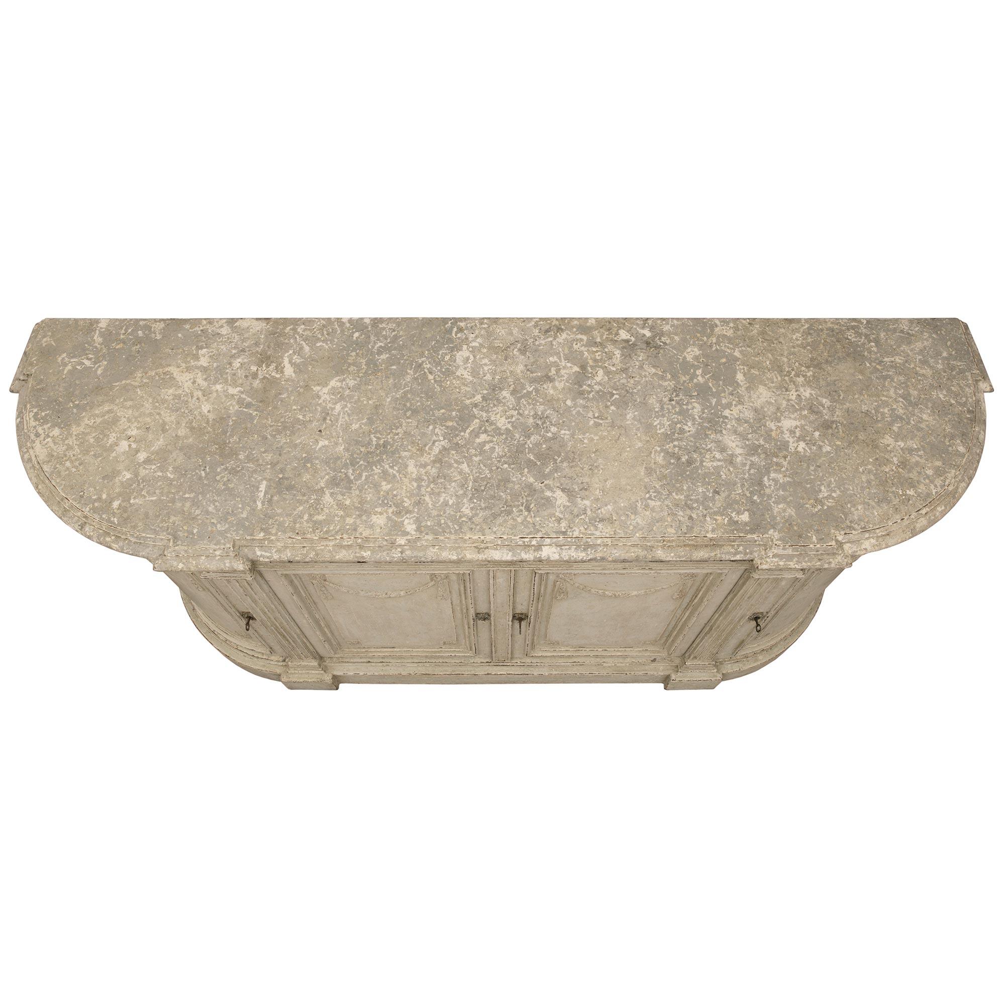 Un elegantissimo buffet francese del XIX secolo in legno patinato Luigi XVI. Il buffet a quattro ante e quattro cassetti è sollevato da una raffinata base screziata con bellissime colonne scanalate che salgono verso l'alto affiancando le ante.
