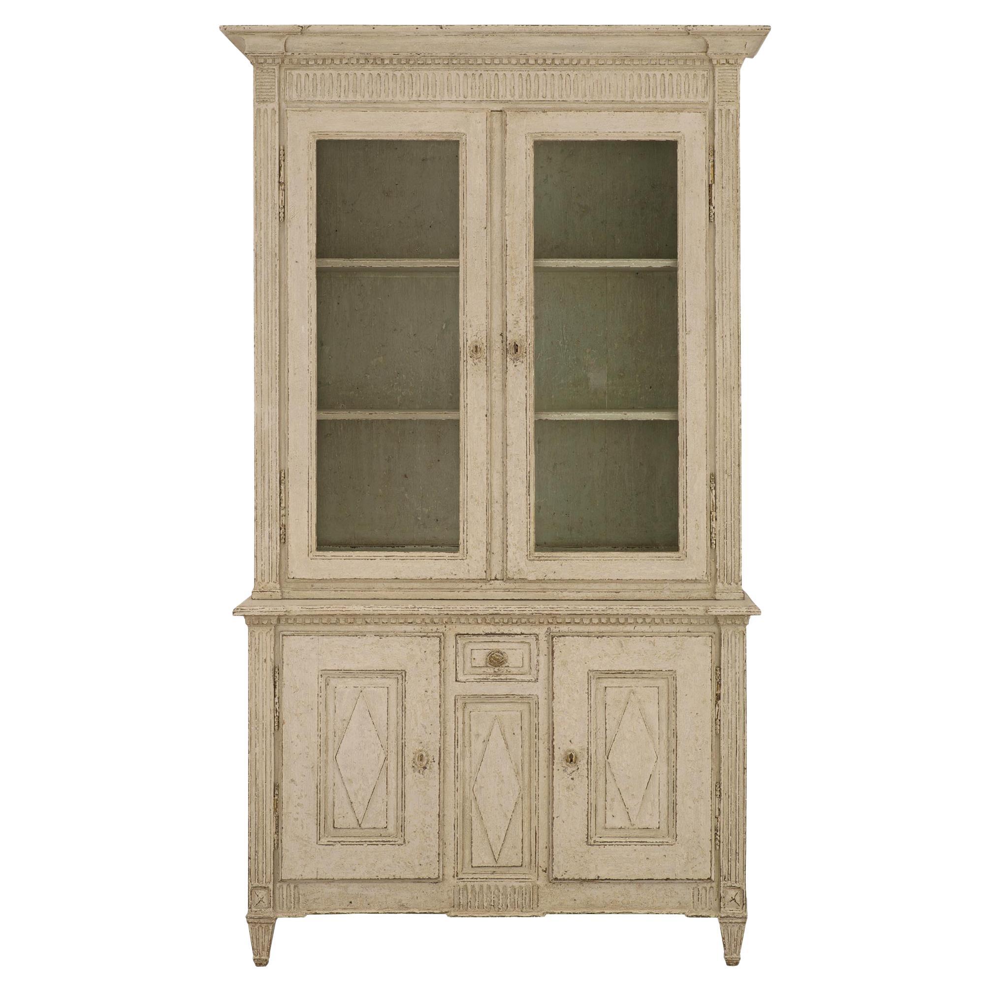 A remarkable and most decorative French 19th century Louis XVI st. patinated wood cabinet vitrine. The four door one drawer vitrine is raised by elegant square tapered fluted legs at the front and fine block legs at the back. The two doors at the