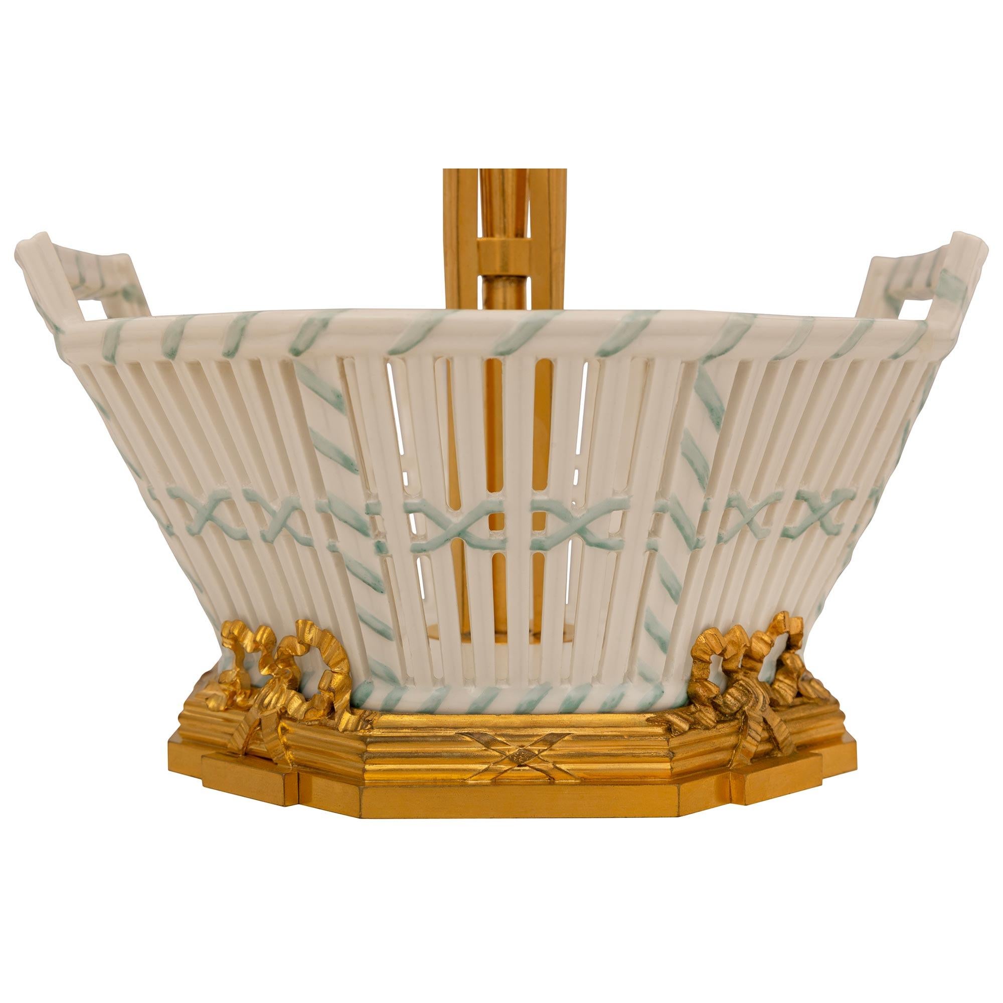 Un élégant ensemble de candélabres et de centres de table en porcelaine et bronze doré de style Louis XVI du XIXe siècle, signé Cardeilhac Paris. L'ensemble est composé de trois paniers en porcelaine, dont deux contiennent trois candélabres en