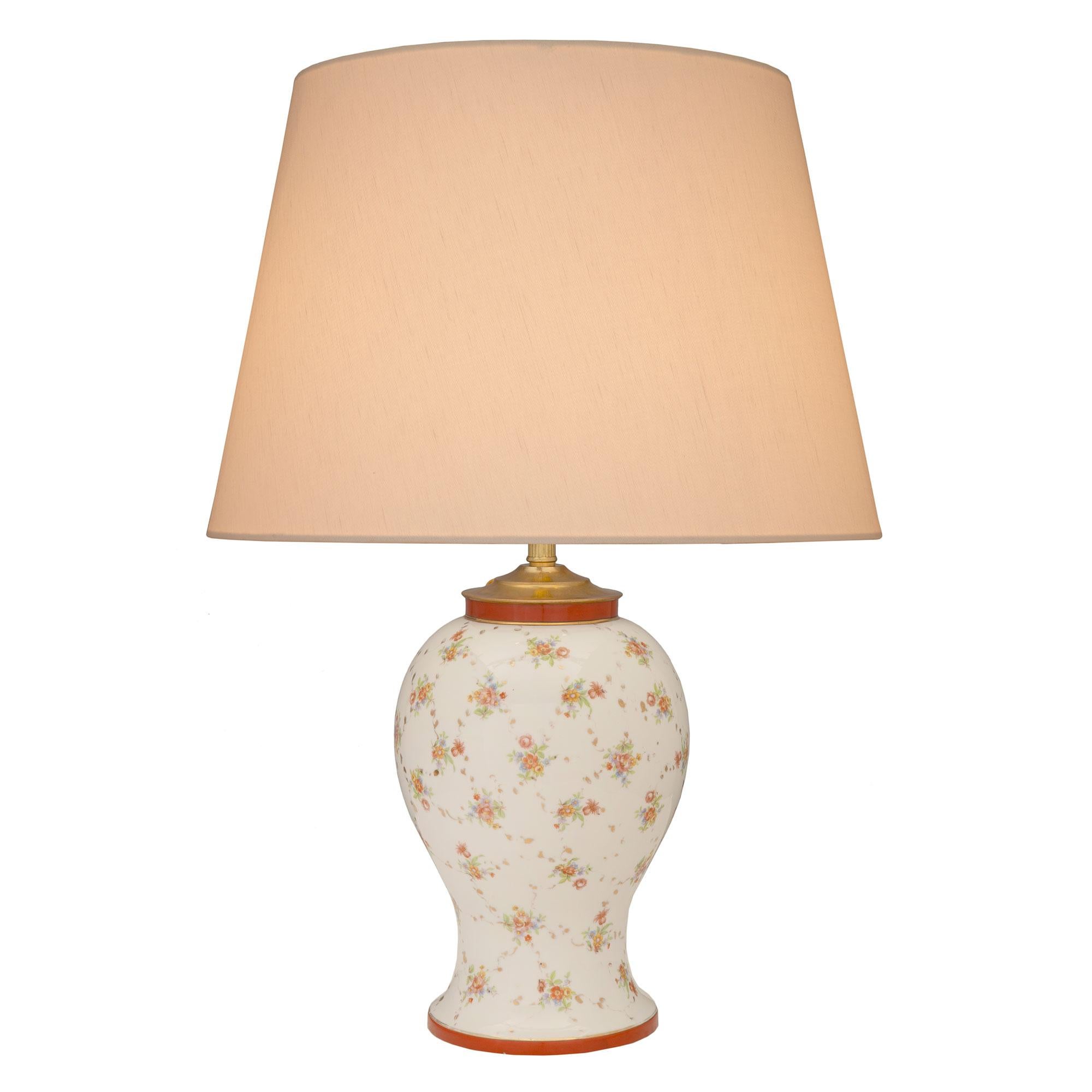 A charming French 19th century Louis XVI st. porcelain lamp. The lamp displays a beautiful and very elegant porcelain body with a lovely baluster shape. The body showcases charming and finely detailed hand painted flowers throughout with gilt