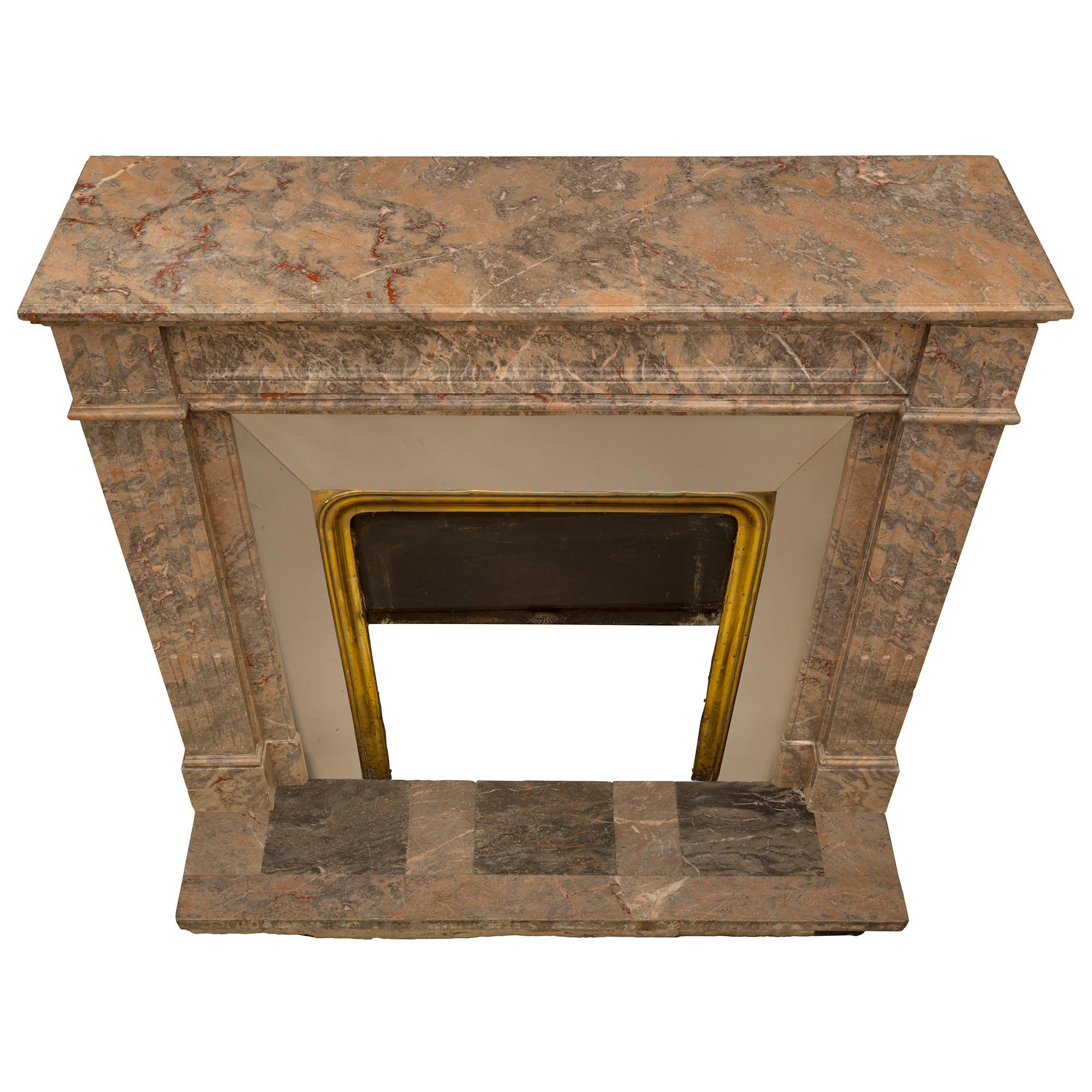 A striking French 19th century Louis XVI st. Sarrancolin and Gris St. Anne marble fireplace mantel. The mantel retains its original rectangular plinth with three square 'Gris St. Anne' marble inserts and its original brass and iron interior with