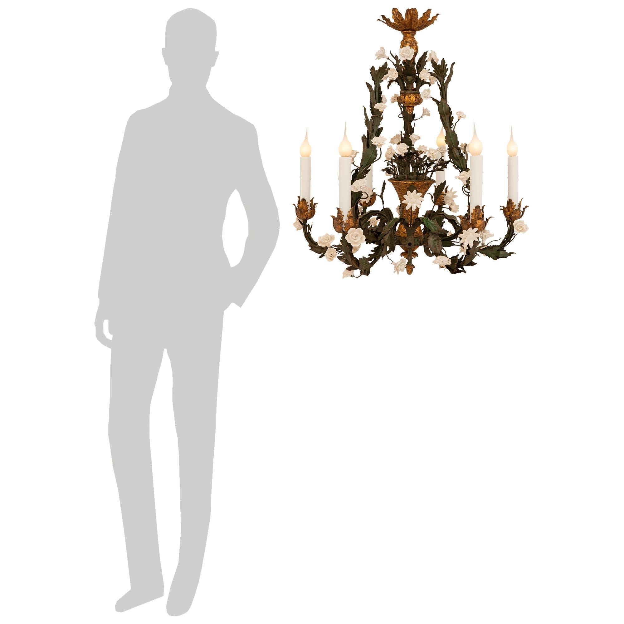Un delizioso ed elegante lampadario francese del XIX secolo in porcellana SAX, metallo dorato e tole. Questo attraente lampadario a sei luci e sei bracci, con la sua doratura e patina originale, è centrato in basso da una ghianda dorata. Sopra il