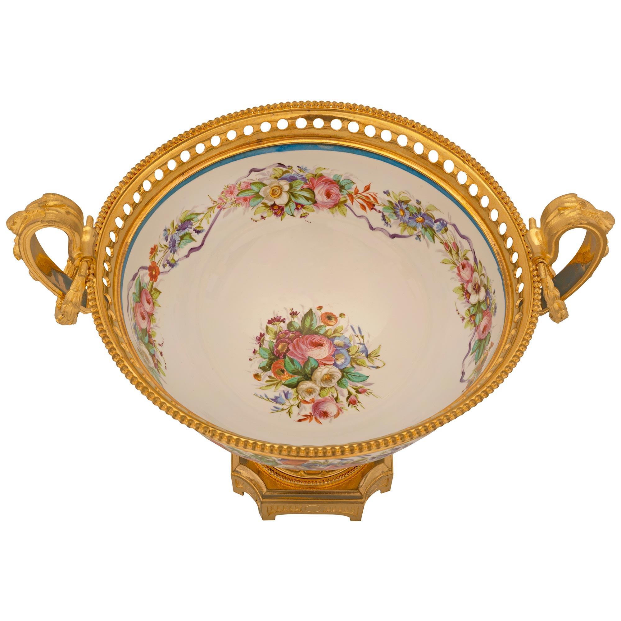 A beautiful and most elegant French 19th century Louis XVI st. Sèvres porcelain and ormolu centerpiece. The oblong shaped centerpiece is raised by a square ormolu base with arched sides, concave corners, fine fluted designs, and a striking fluted