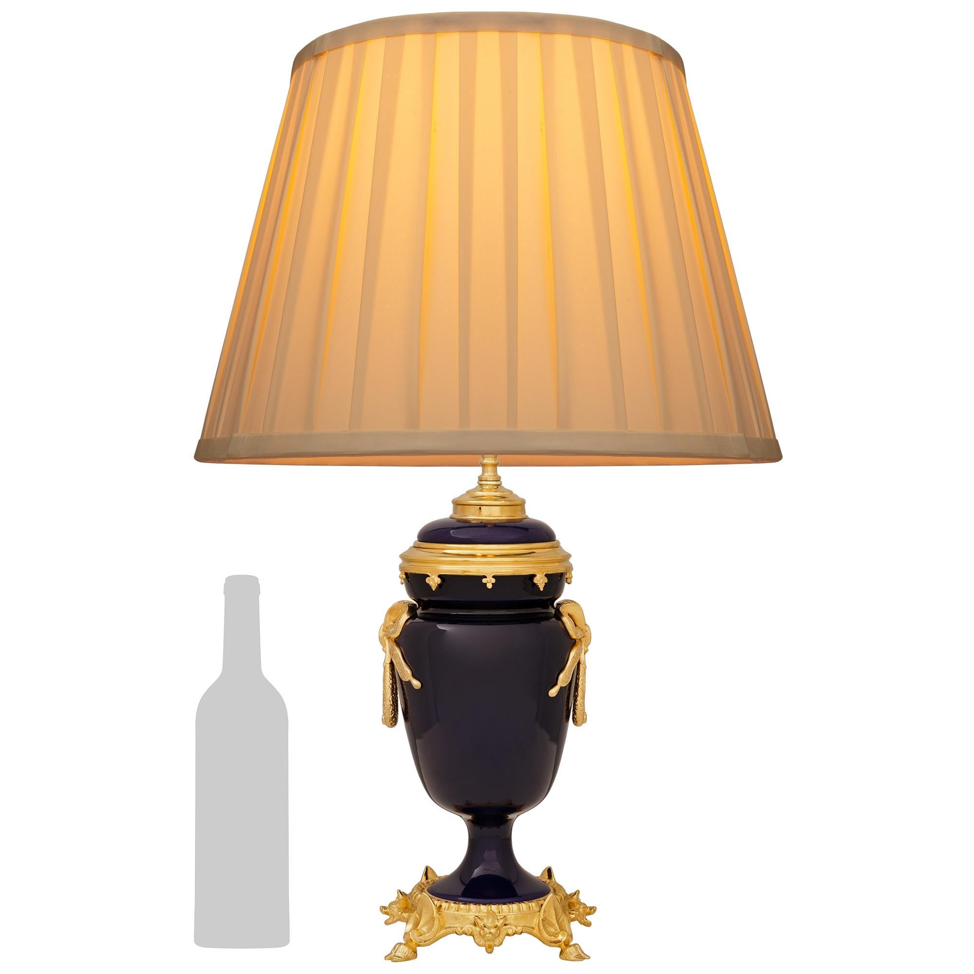 Très belle lampe en porcelaine de Sèvres et bronze doré de style Louis XVI du 19ème siècle. Cette magnifique urne à couvercle montée en lampe est surmontée d'une base circulaire en bronze doré avec des supports d'angle en forme de feuilles au-dessus