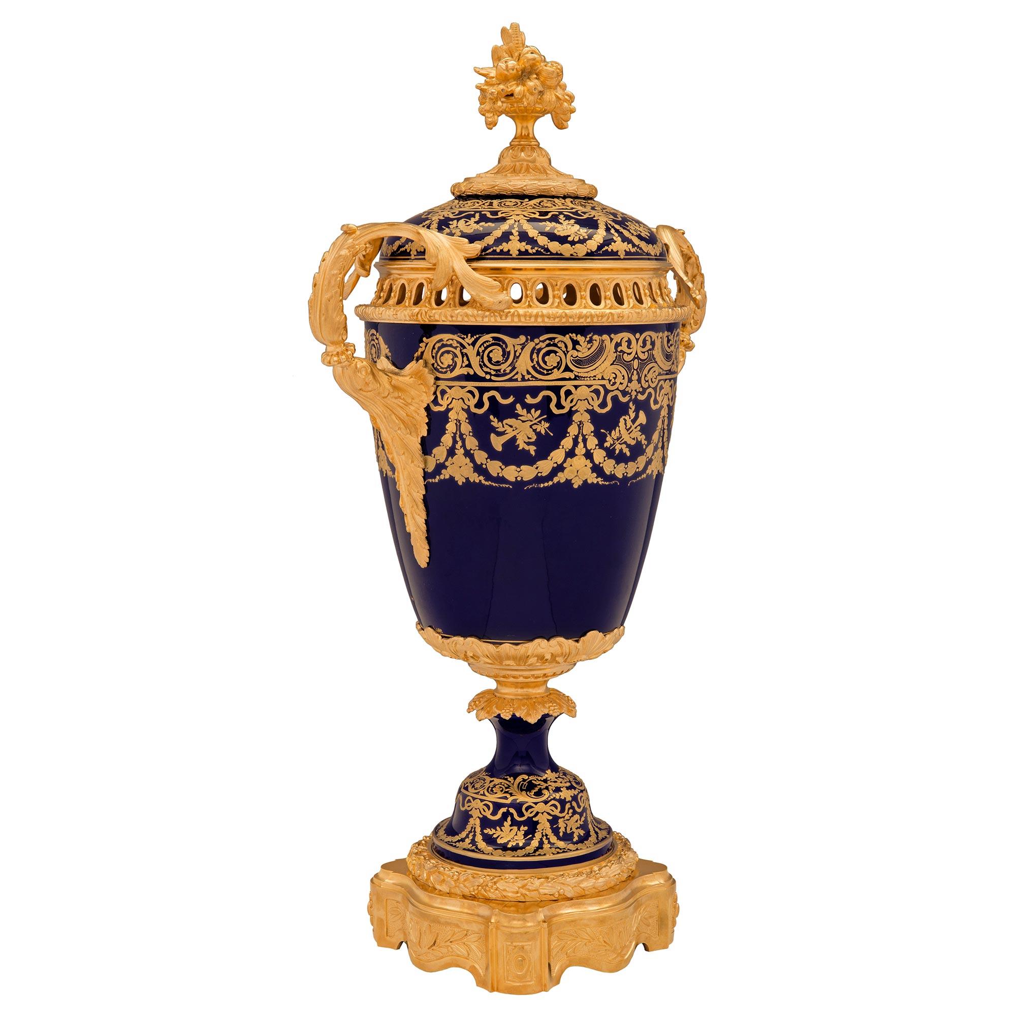 Un'urna con coperchio in porcellana di Sèvres, firmata Sèvres, di altissima qualità, risalente al XIX secolo Luigi XVI, periodo Belle Époque. L'urna blu cobalto è sollevata da un'eccezionale base quadrata in ormolu con bellissimi lati smerlati che