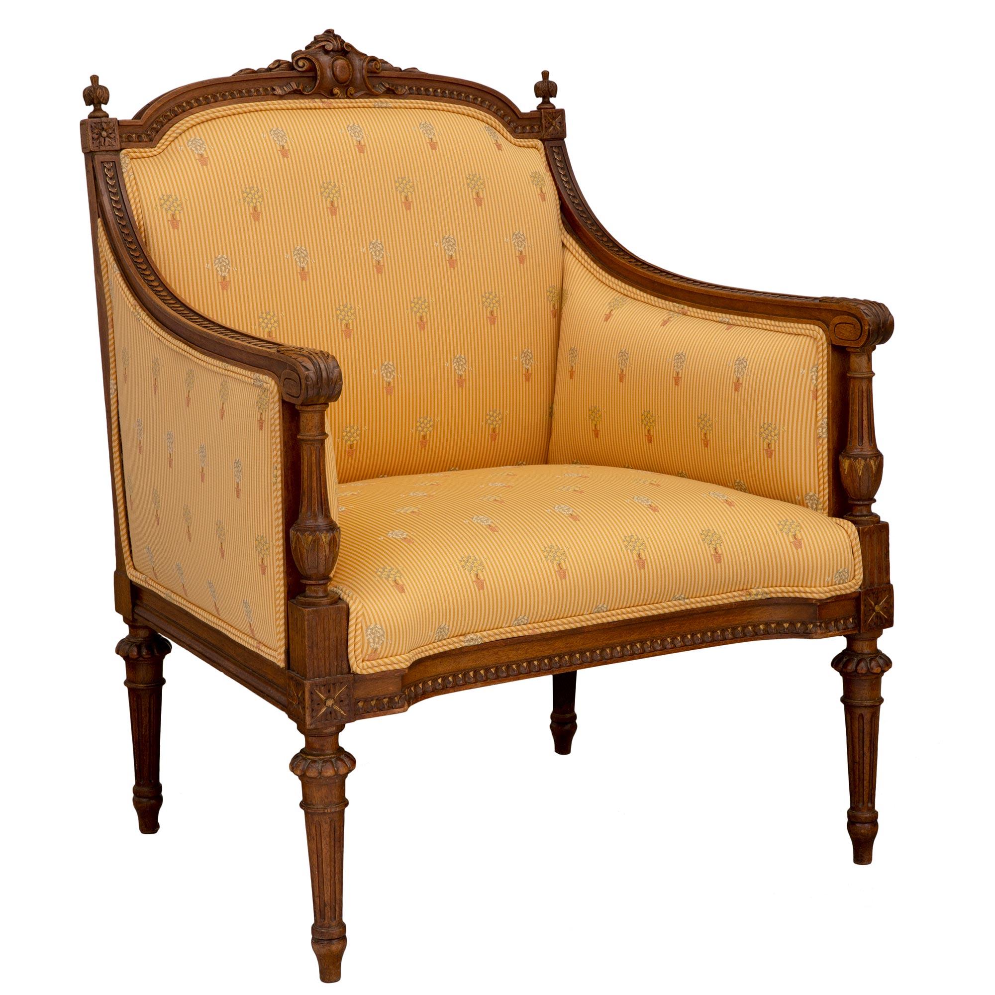 An exquisite French 19th century Louis XVI st. solid oak Marquise armchair. The armchair is raised by elegant circular tapered fluted legs below a fine Coeur de Rai pattern which extends along the apron. Each arm displays most decorative carved