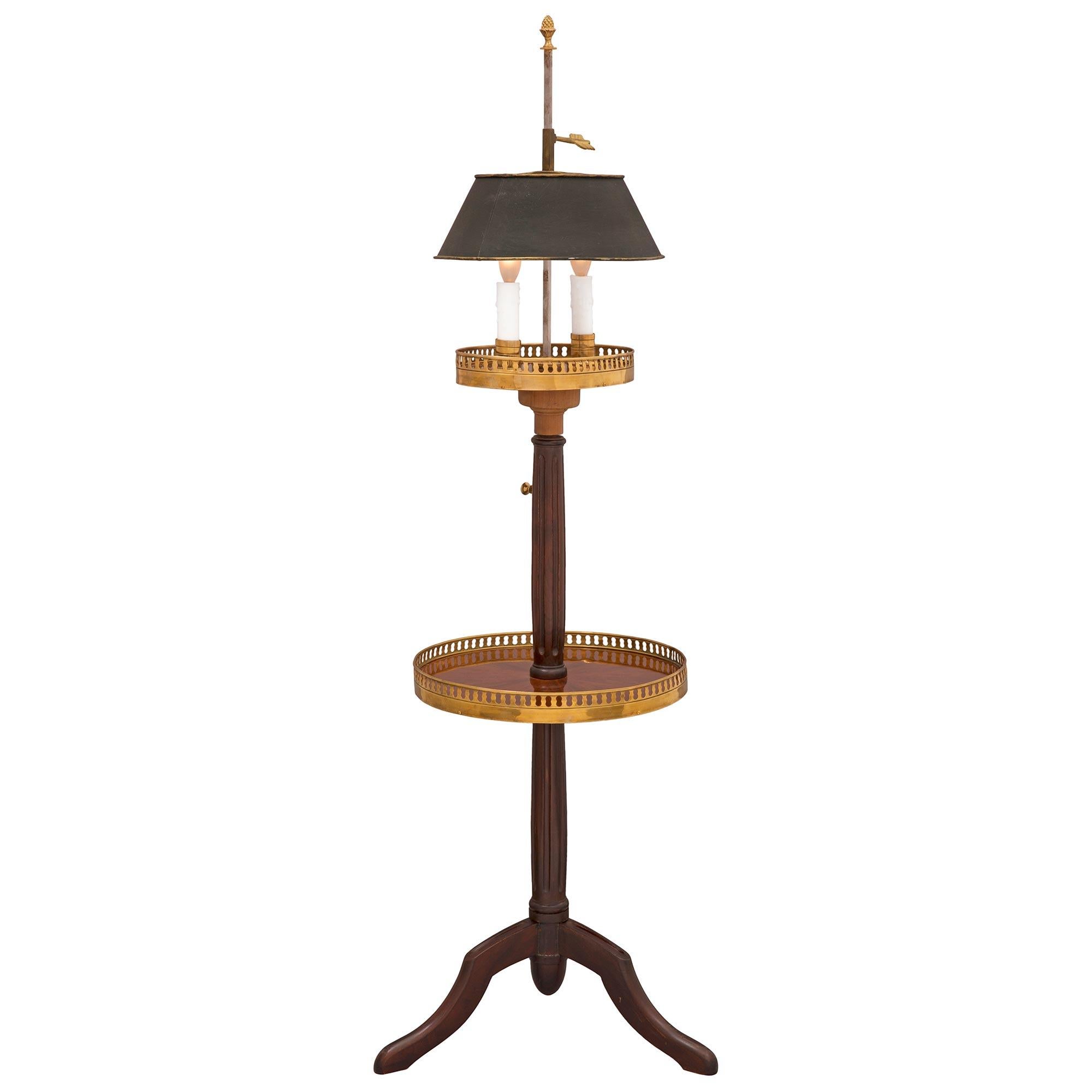 A charming and very unique French 19th century Louis XVI st. Mahogany and ormolu side table/lamp. The two tiered table is raised by three elegantly curved legs below a baluster shaped circular fluted support. At the center is a circular display tier