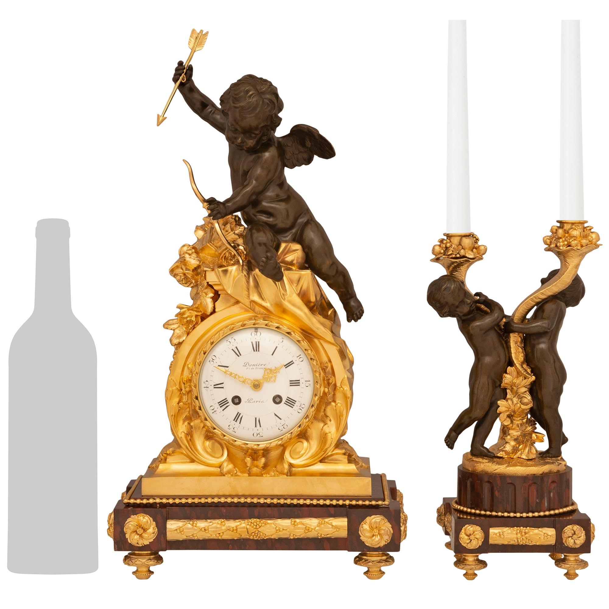 Un sensationnel ensemble de trois pièces de garniture de haute qualité, signé Denière, Paris, de style Louis XVI du 19e siècle. L'élégant ensemble comprend une paire de candélabres à deux bras reposant sur des socles carrés en marbre Rouge Griotte