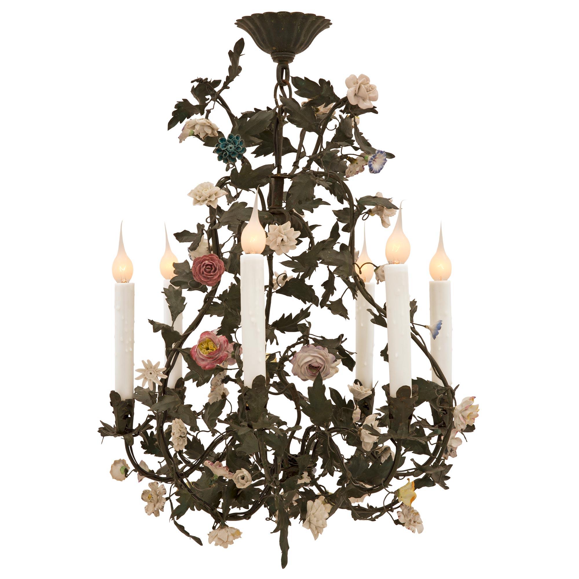 A charming French 19th century Louis XVI st. tole and Saxe porcelain chandelier. The six arm chandelier displays a lovely curvaceous cage adorned with elegant tole leaves and a stunning array of colorful intricately detailed hand painted Saxe
