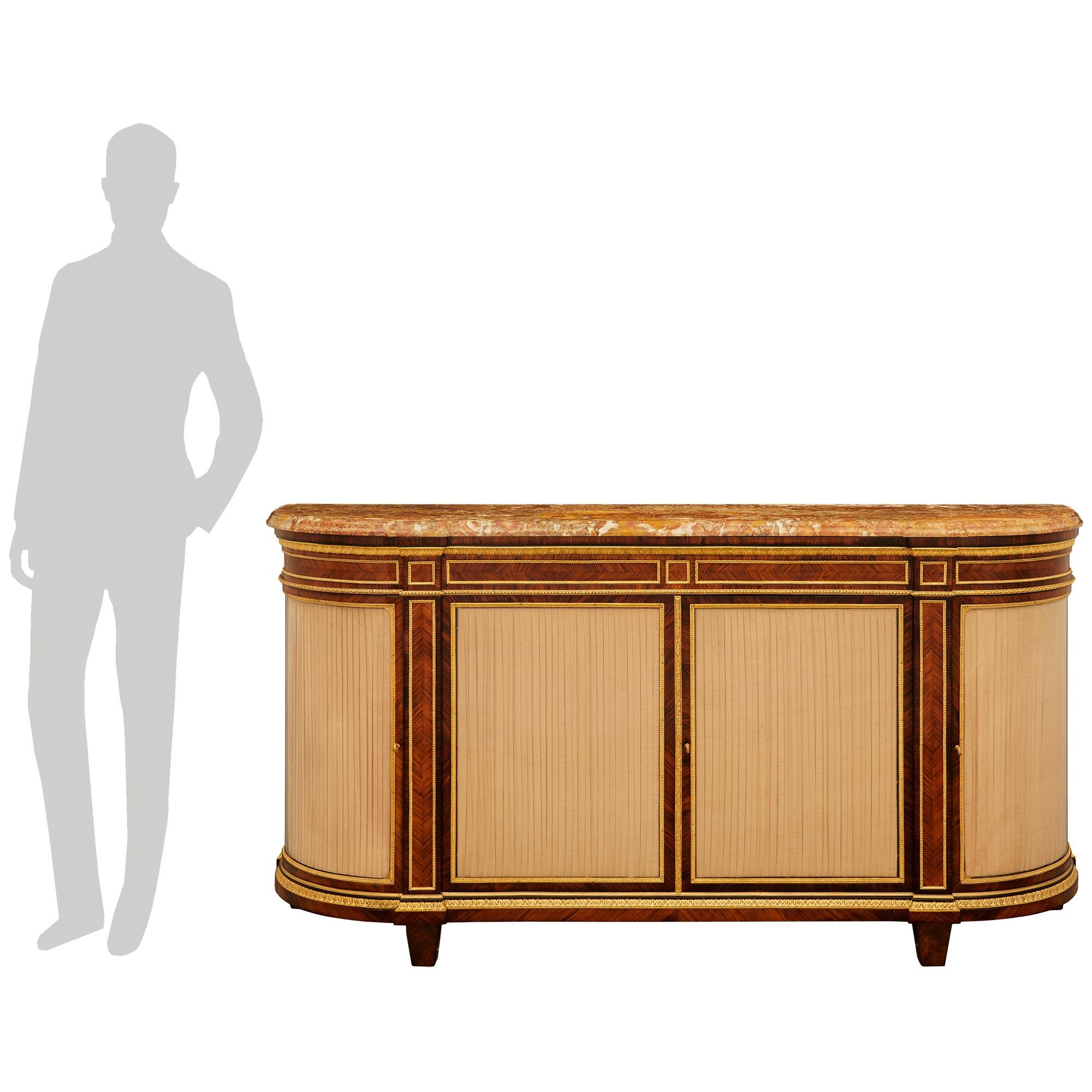 Un imponente e pregiato buffet francese del XIX secolo in legno di tulipano, Kingwood, Ormolu e marmo di Breccia Pernice. Questo meraviglioso buffet è sollevato da piedi rettangolari affusolati sotto la base a forma di demi lune ornata da un bordo
