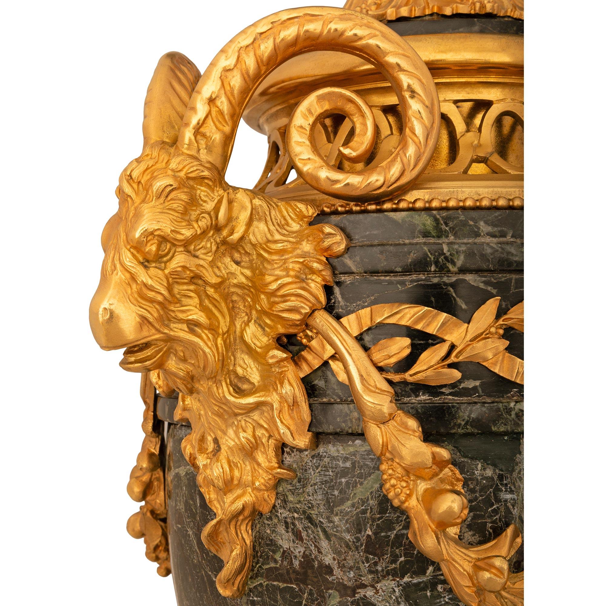 A stunning French 19th century Louis XVI st. Vert de Patricia marble and Ormolu lidded urn. The urn is raised by a square Vert de Patricia marble base with and Ormolu trim. The socle pedestal is decorated with an Ormolu tied wreath and reeded top