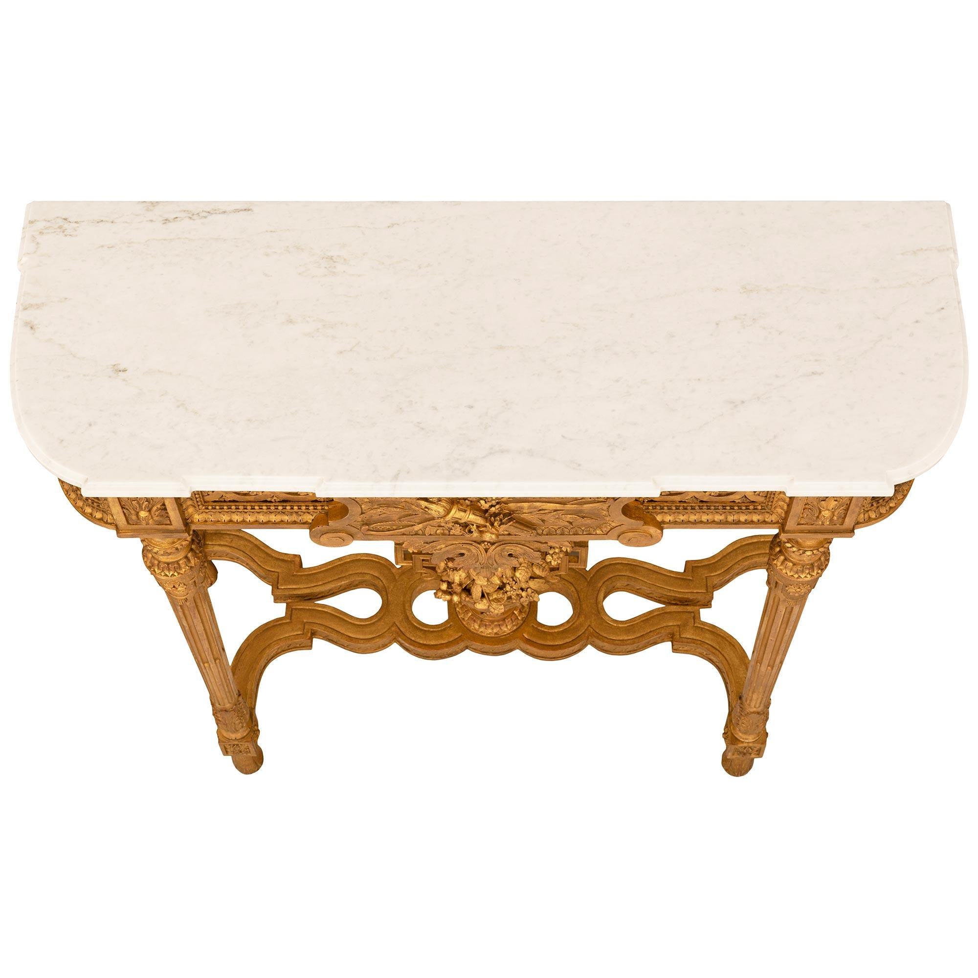 An exquisitely detailed French 19th century Louis XVI st. white Carrara marble and Giltwood console. The 