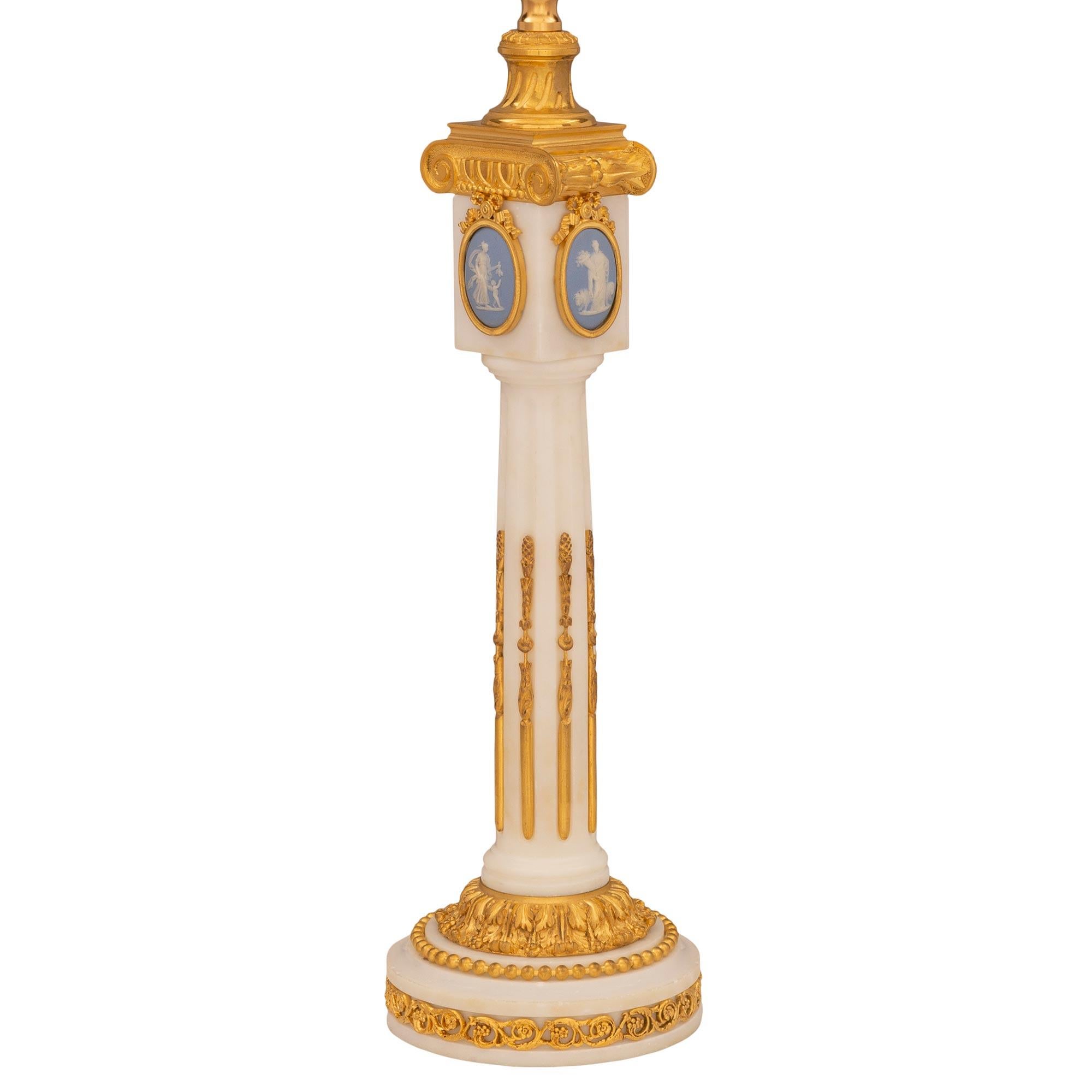 A most elegant French 19th century Louis XVI st. white Carrara marble, ormolu, and Wedgwood lamp. The lamp is raised by a circular base decorated with a beautiful fitted pierced Rinceau shaped scrolled foliate ormolu band and a lovely foliate wrap