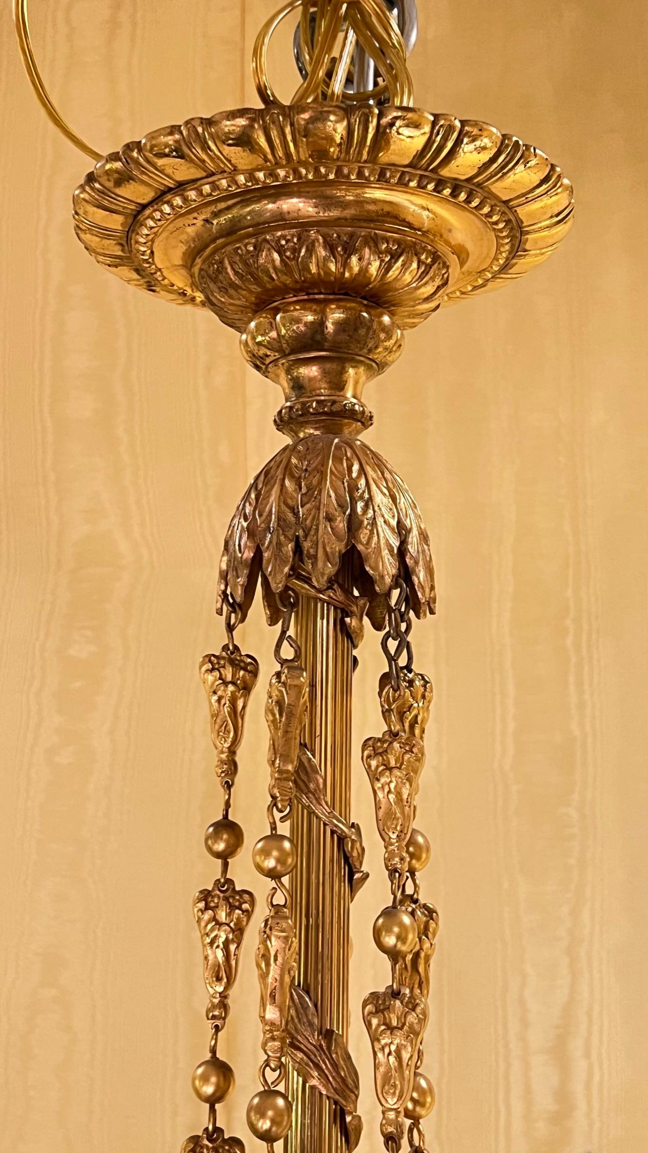 19th century French Louis XVI style ten-light gilt bronze chandelier in the manner of Pierre Gouthiere.  With modern sockets and wiring, ready for installation.
