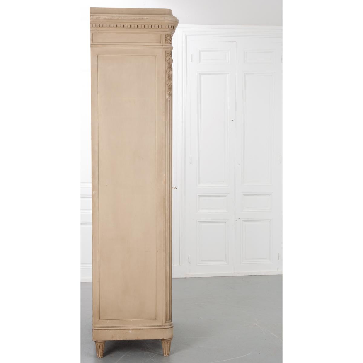 French painted armoire with a single mirrored door. Exquisite details grace this piece, top to bottom. Impressive dentil crown moulding sits atop a recessed panel, framed frieze with florets set into the rounded corners. The large mirrored door has