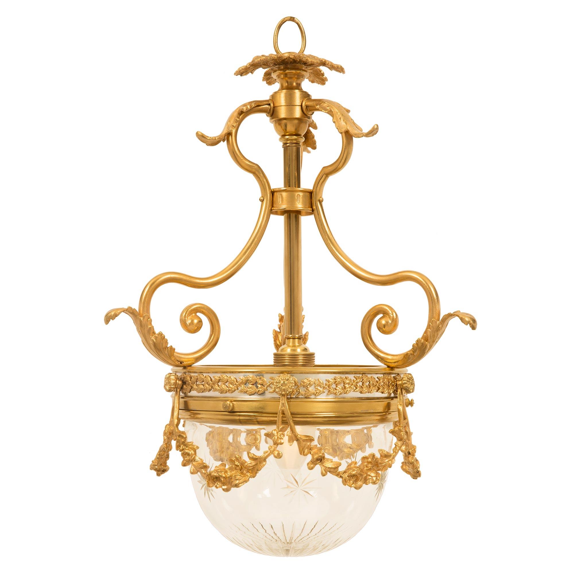 An outstanding French 19th century Louis XVI st. Belle Époque period ormolu and crystal chandelier. The chandelier is centered by a magnificent cut crystal bottom dome with lovely and most decorative cut stars. The central rim displays a fine wrap