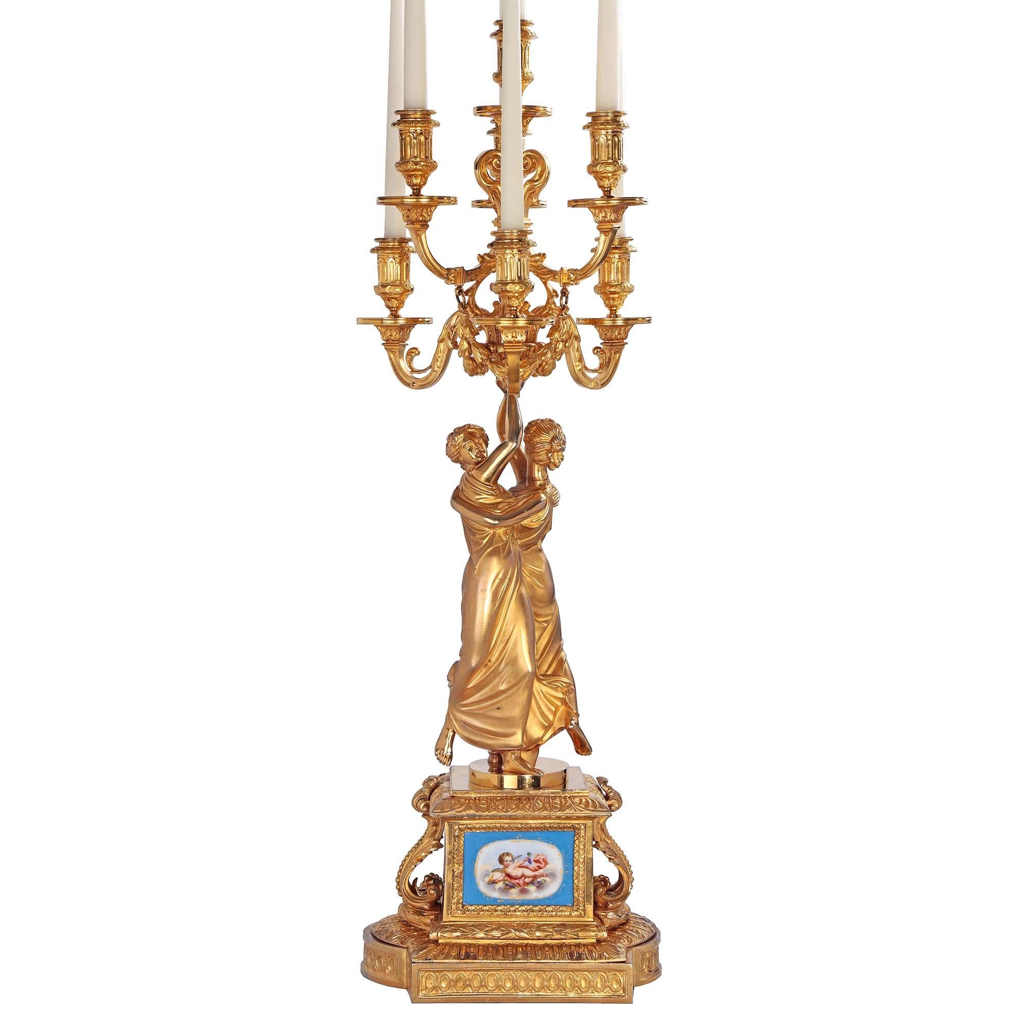 A stunning true pair of French 19th century Louis XVI st. Belle Epoque period ormolu and Sèvre sporcelain candelabras. Each seven arm candelabra is raised by a rectangular base with elegant rounded sides and recessed ormolu oval patterns. The