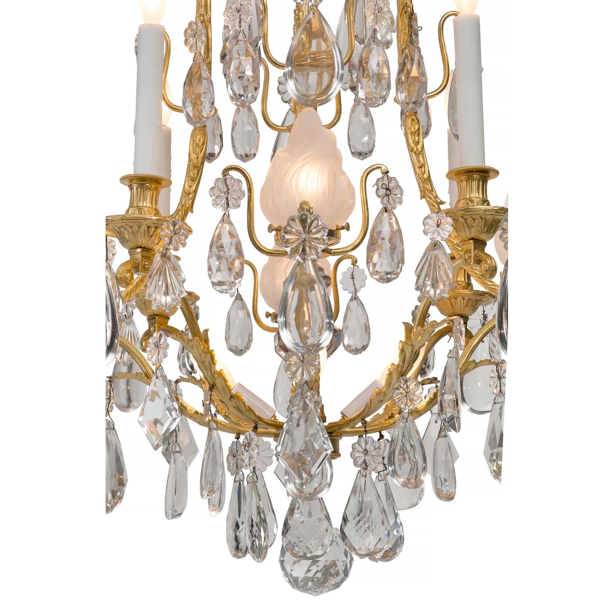 A stunning French 19th century Louis XVI st. Belle Epoque period ormolu and Baccarat crystal chandelier. The chandelier is centered by a beautiful cut crystal ball amidst striking smooth and cut tear drop and prism shaped crystals. Each arm is