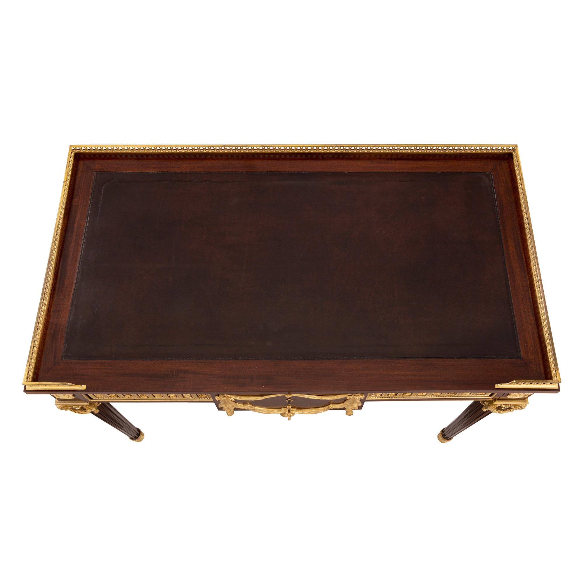 A stunning and extremely high quality French 19th century Louis XVI st. Belle Époque period mahogany, ormolu and leather desk, signed Henry Dasson 1877. The desk is raised by elegant circular tapered legs with beautiful fitted foliate sabots and
