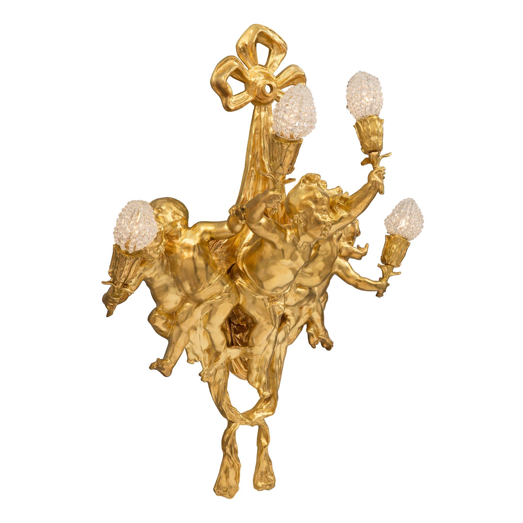Llamativo candelabro de cuatro brazos de estilo Belle Époque francés del siglo XIX. El candelabro está centrado por una preciosa tela de swaging atada en la parte inferior. En el centro hay cinco encantadores querubines ricamente cincelados que