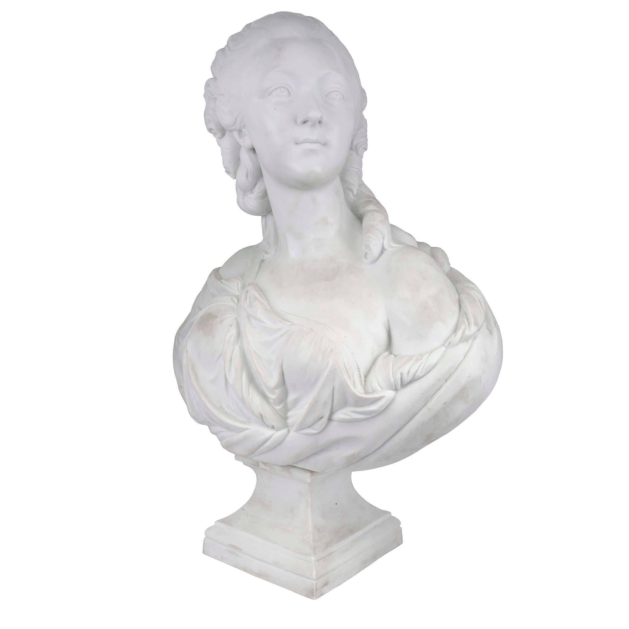 A large-scale French 19th century Louis XVI st. Biscuit de Sèvres Porcelain bust of Madame La Contesse Du Bary in the manner of the sculptor Pajou. The bust is raised by a square socle with a mottled border. The Contesse in draped in classical dress