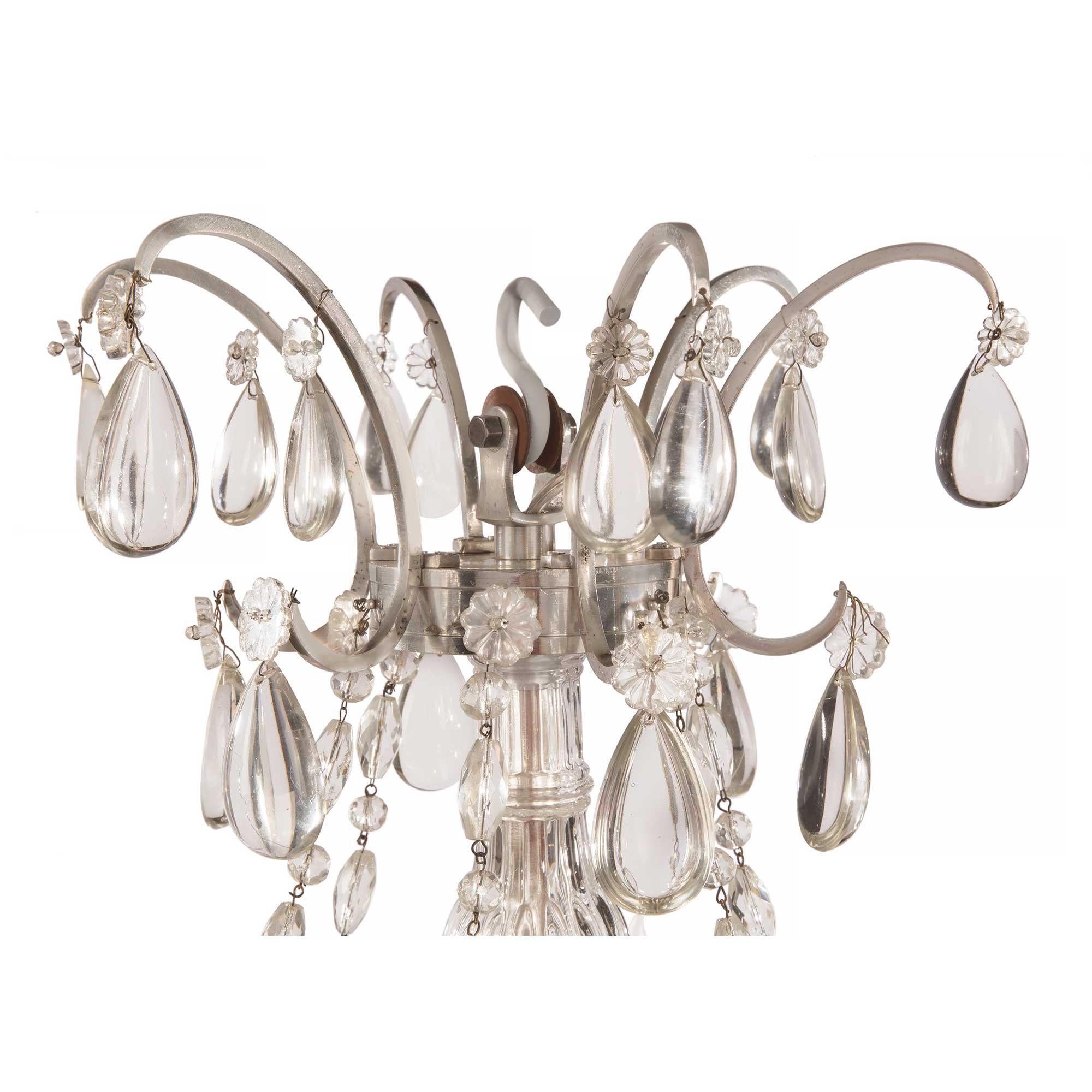 An elegant French 19th century Louis XVI st. silvered bronze and Baccarat crystal six arm chandelier. The chandelier is centered by a fine solid Baccarat crystal ball below a lovely silvered bronze tier hung by fine beaded garlands and adorned with