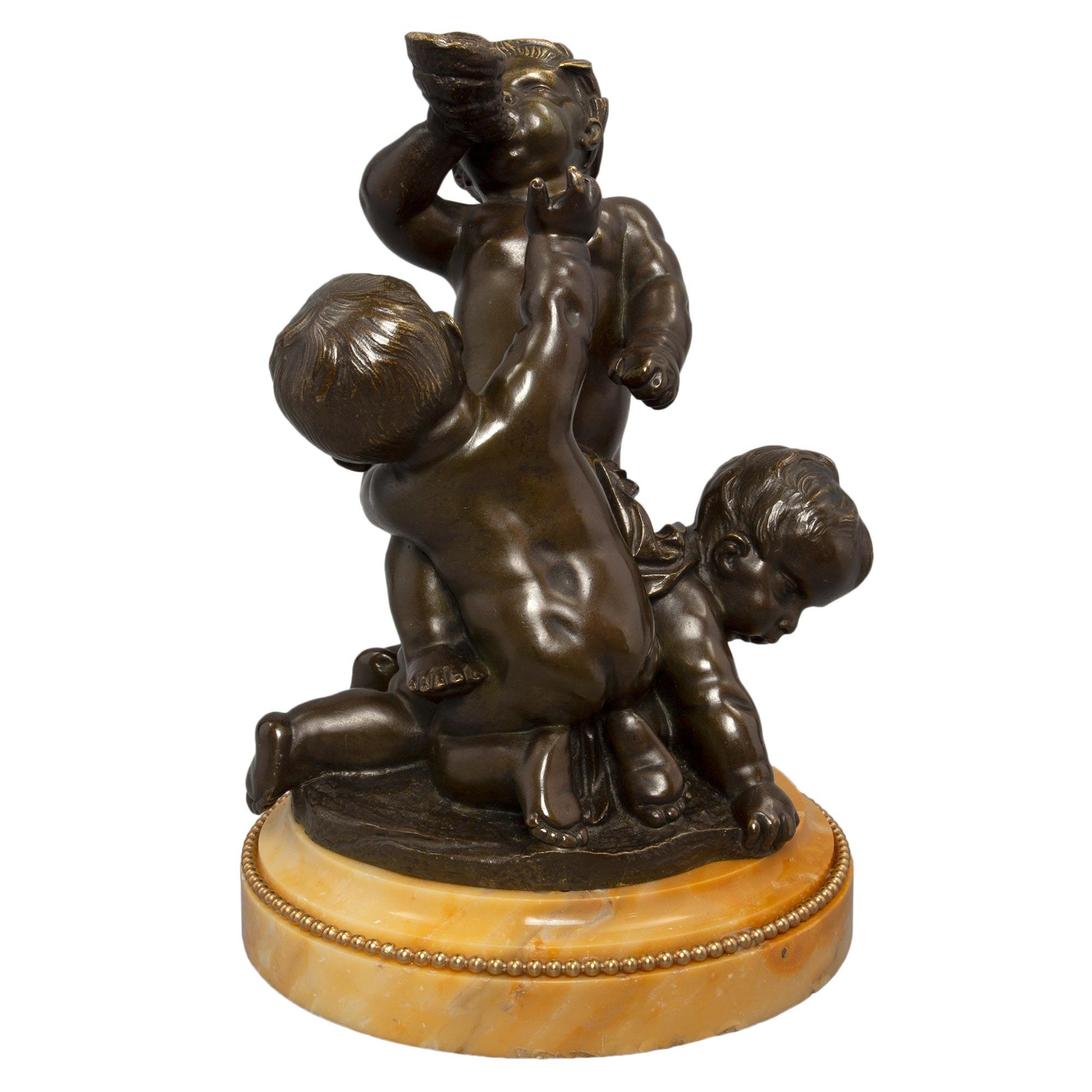 A charming and high quality French 19th century Louis XVI st. patinated bronze, ormolu, and Sienna marble statue. The small scale grouping of three charming cherubs is raised by a circular Sienna marble base with a stepped mottled border with a