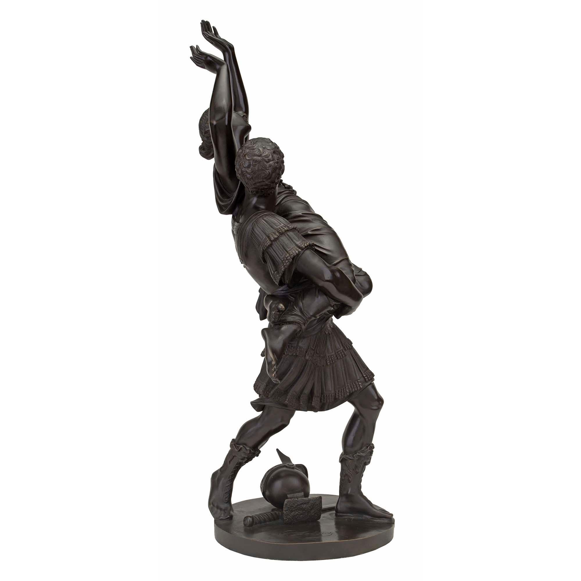 A striking French 19th century Louis XVI st. bronze statue of L'Enlevement des Sabines signed Raingo Frères. The high quality bronze is raised by a circular base where the soldier's helmet and sword are lying on the ground. The handsome soldier is