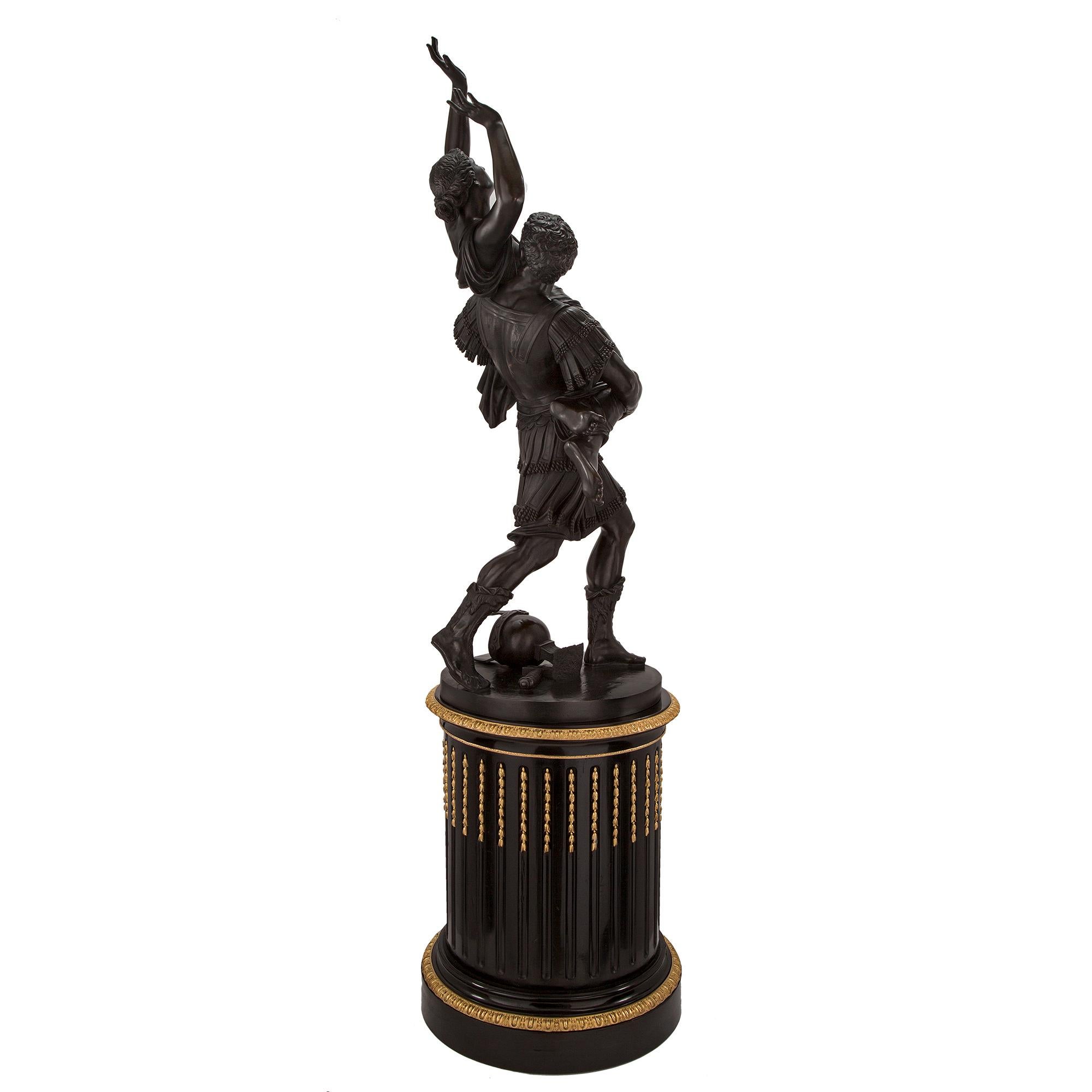 A sensational and large scale French 19th century Louis XVI st. bronze statue of L'Enlevement des Sabines on its original Base. The high quality bronze is raised by a circular fluted ebony base with fine and most decorative ormolu bands and striking