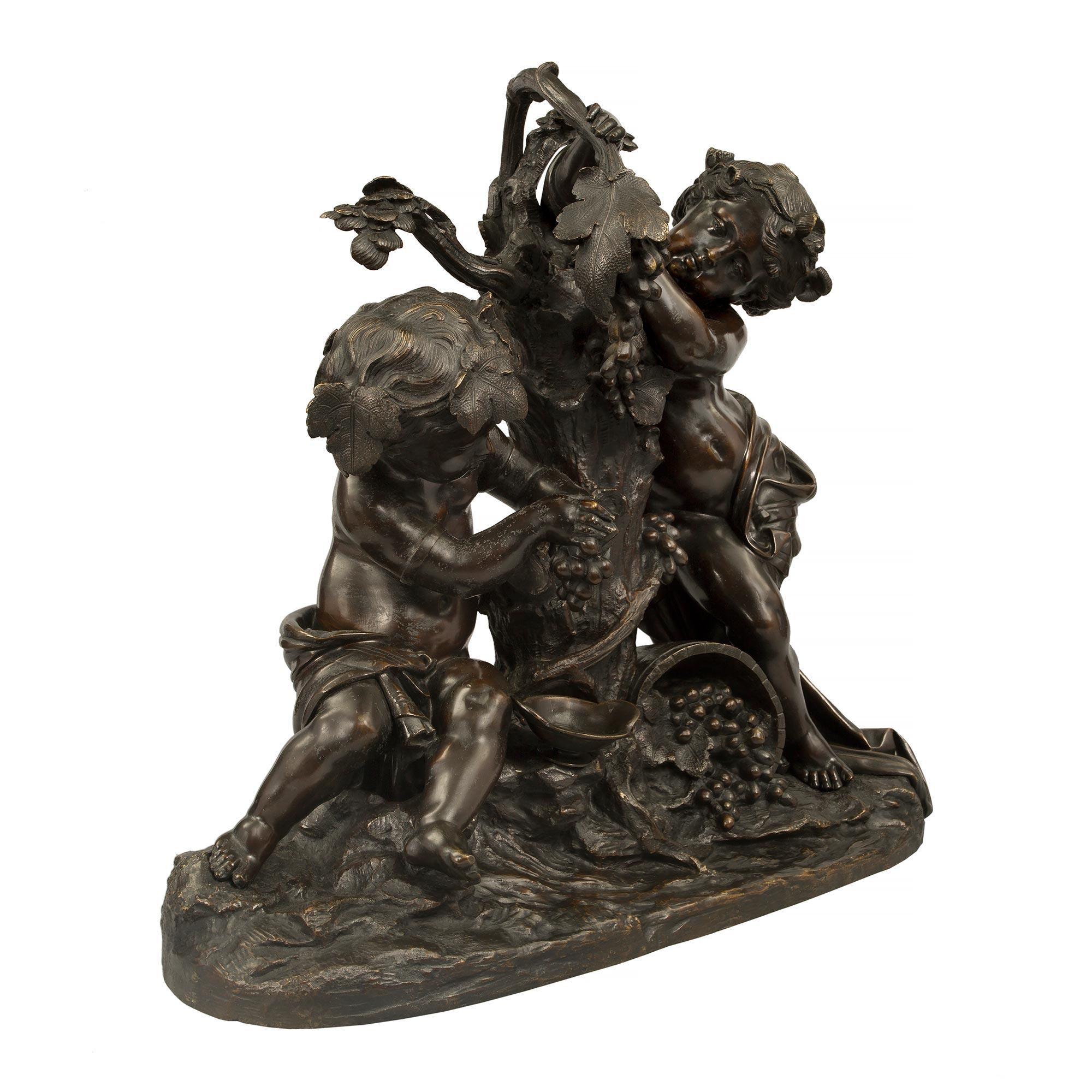 Eine auffallende und qualitativ hochwertige französische Bronzestatue aus dem 19. Jahrhundert im Stil Louis XVI, patiniert, signiert mit Clodion, die zwei Putten beim Weinmachen darstellt. Die Statue steht auf einem länglich geformten Sockel mit
