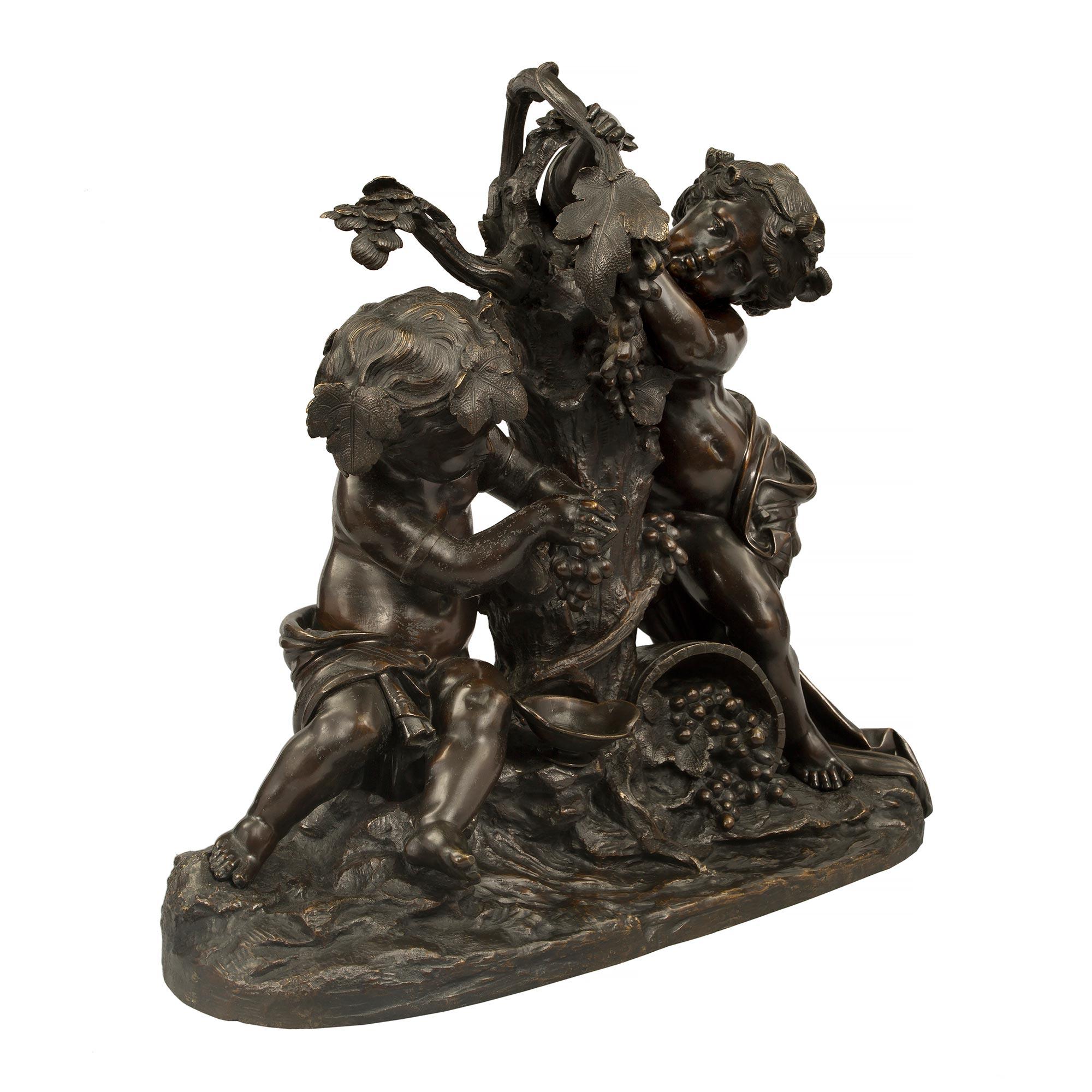 Statua in bronzo patinato di alta qualità del XIX secolo Luigi XVI, raffigurante due putti che preparano il vino, firmata Clodion. La statua è sollevata da una base di forma oblunga con un meraviglioso disegno del terreno. In alto sono raffigurati