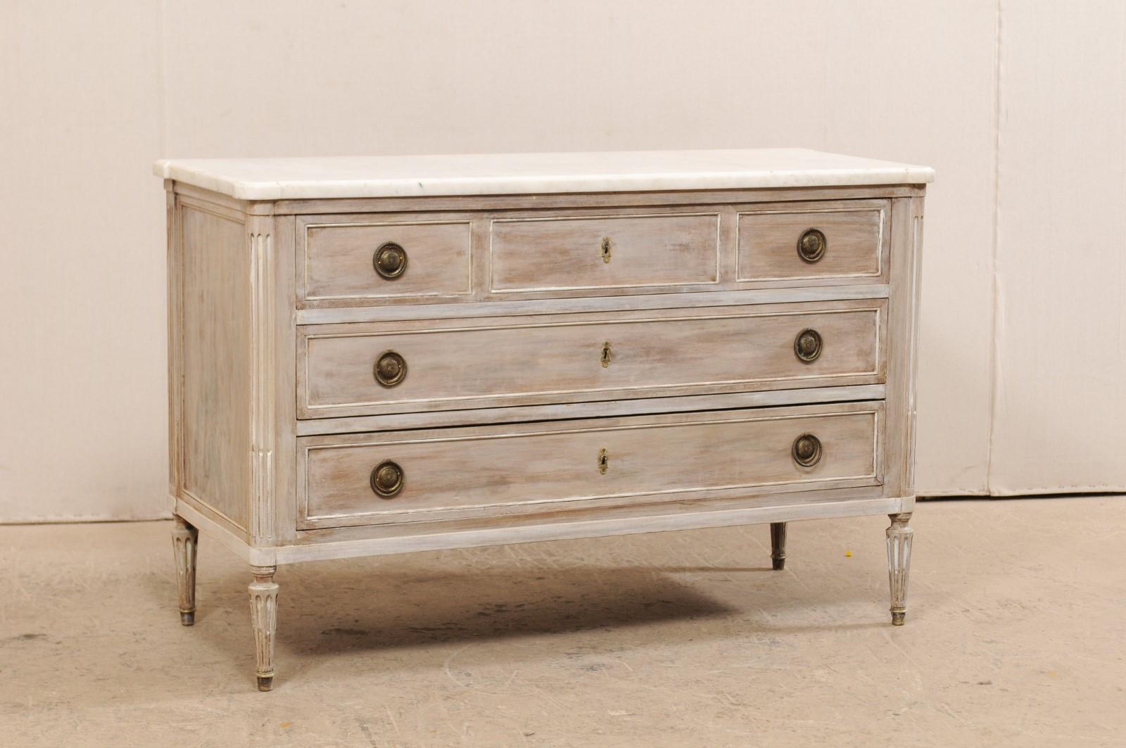 A French 19th century carved wood chest of drawers with marble top. This lovely Louis XVI style antique chest from France features a marble top with rounded, pronounced semi-circular edges at both front corners, atop a case of three full-sized