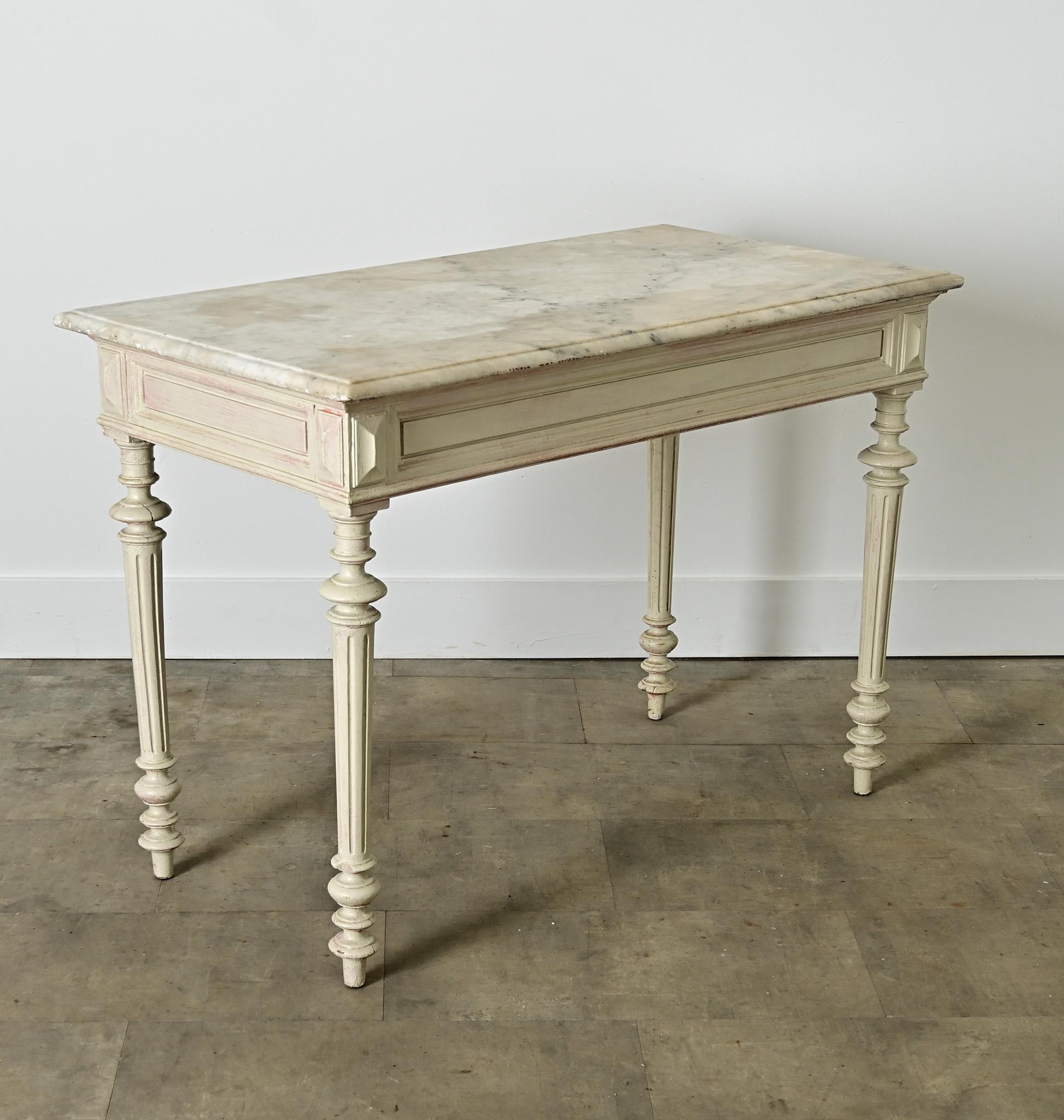 A versatile Louis XVI style center table from the 19th century, it has excellent proportions and color to suit a number of functions around the home from console, to occasional table, to writing desk. The removable, white marble top is shaped to an