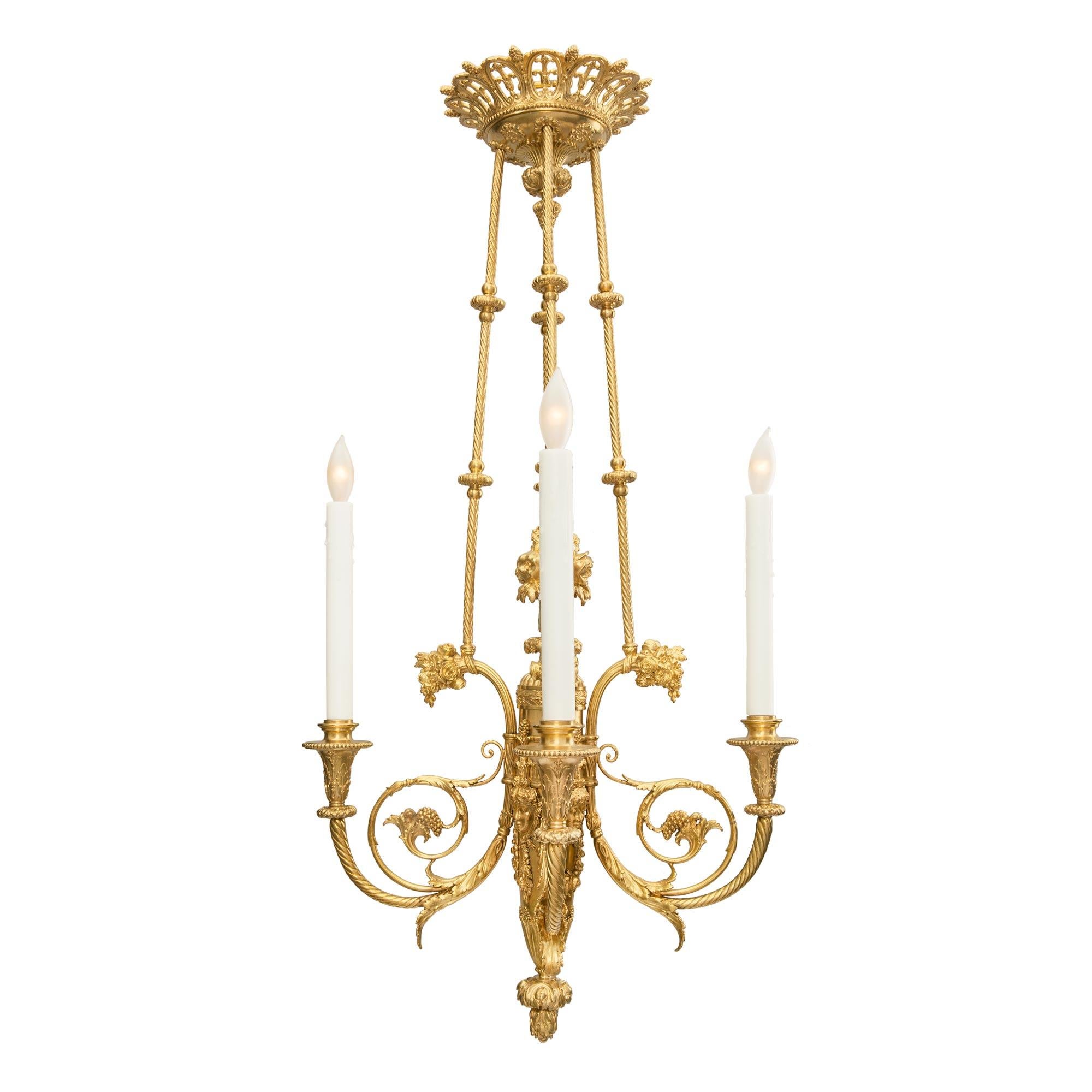 An extremely elegant and high quality French 19th century Louis XVI st. ormolu four arm chandelier signed F. BARBEDIENNE PARIS. The chandelier is centered by a beautiful berried foliate inverted bottom finial below lovely laurel leaves. The striking
