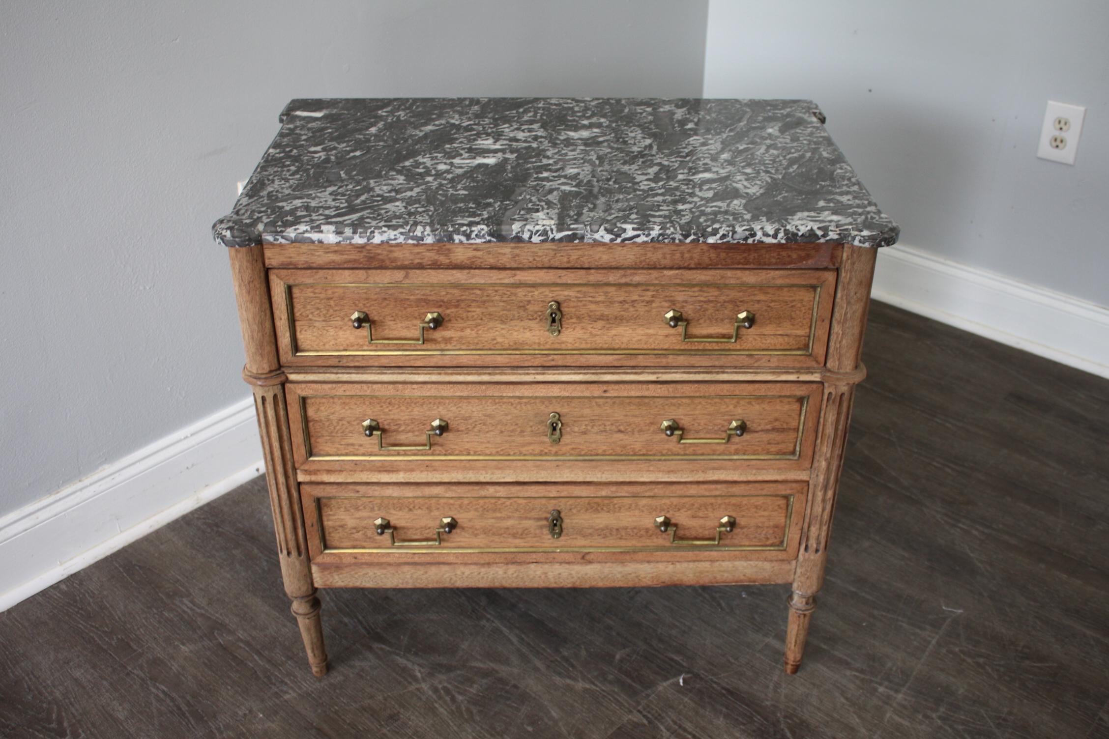 Small Louis XVI style commode with brass around the drawers and a Sainte-Anne Marble top.