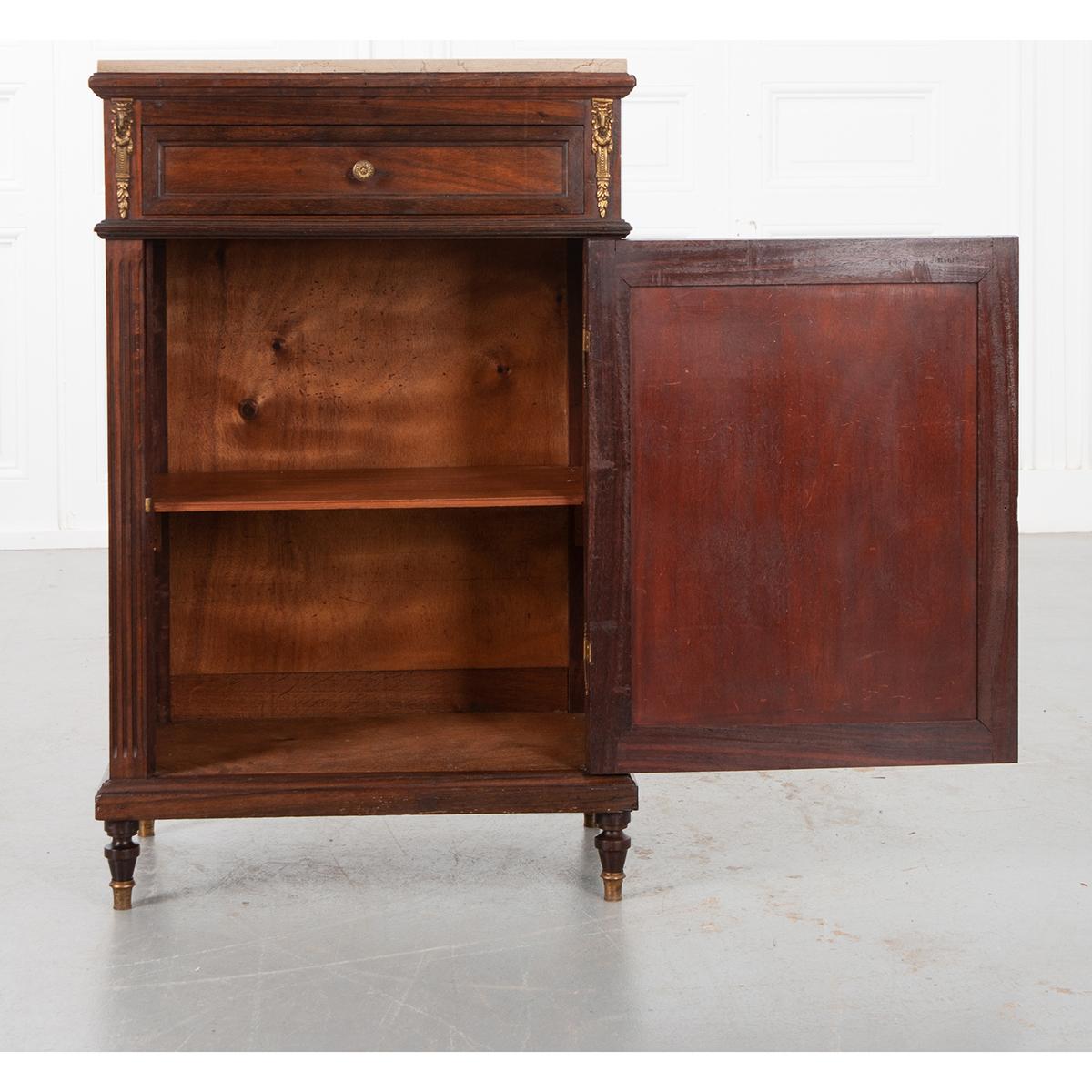 A specialized cabinet made for keeping jams, jellies and marmalades, this 19th century French Louis XVI- style confiturier is ideally sized to meet a number of storage needs. The marble top sits on a multi-wood piece with one drawer and one door. It