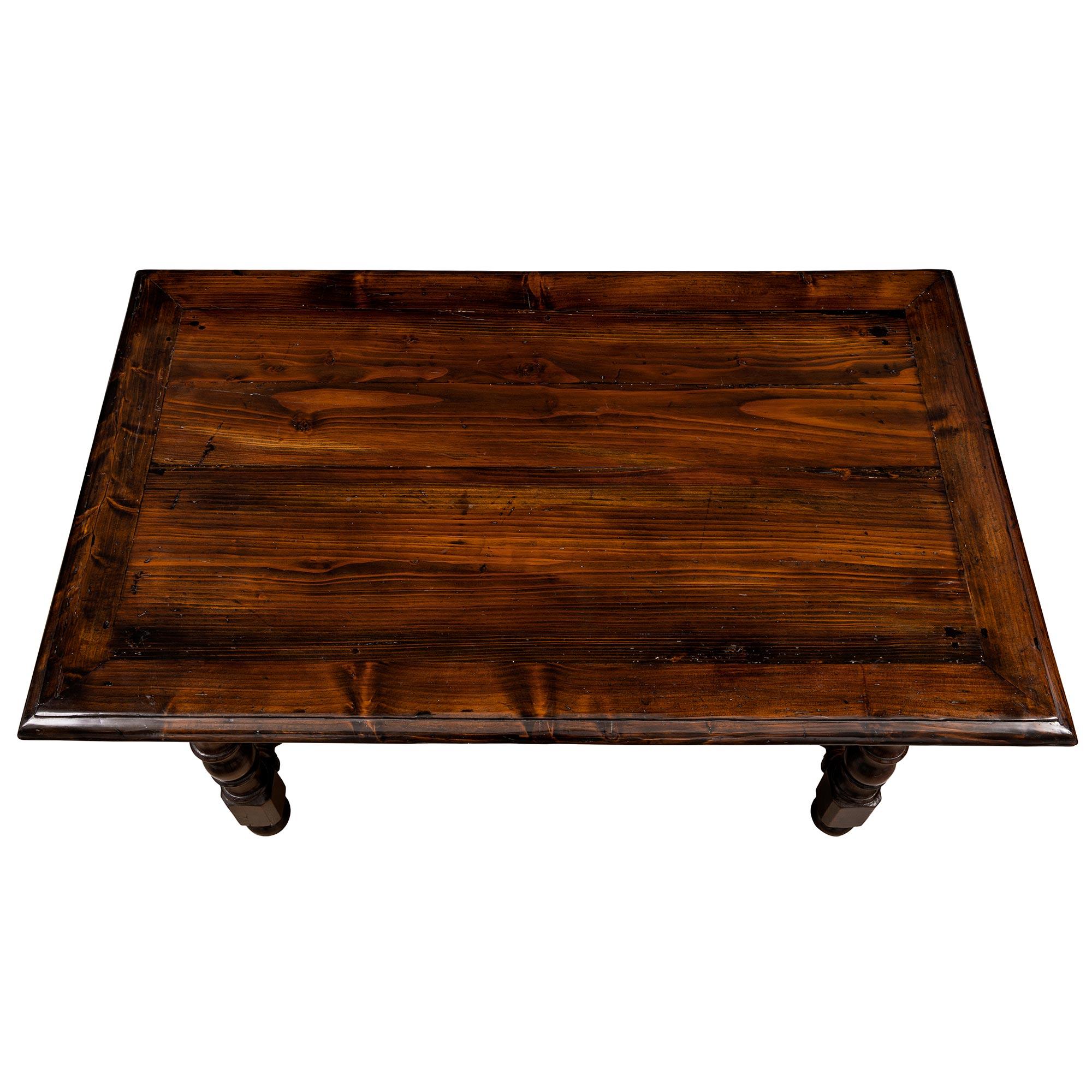 A handsome country French 19th century Louis XVI style dark oak center table. The table is raised by lovely ball feet below impressive turned legs with block reserves. Each leg is connected by a most decorative turned stretcher with a lovely central