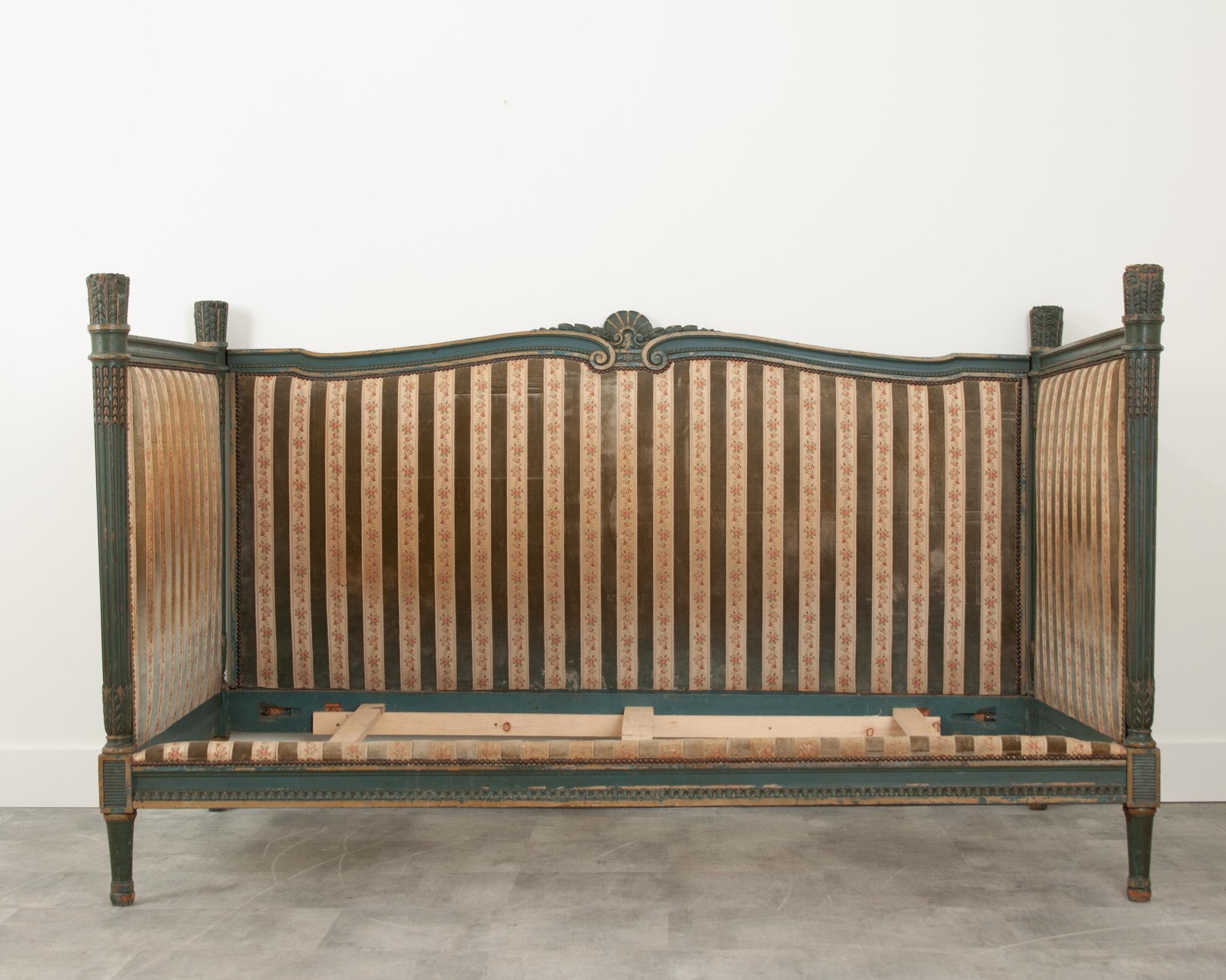 A fantastic Louis XVI style daybed from France circa 1830’s.  The worn original blueish green painted frame has a wonderful patina.  Green velvet and floral fabric beautifully compliment one another; secured by decorative metal nail heads. Elements