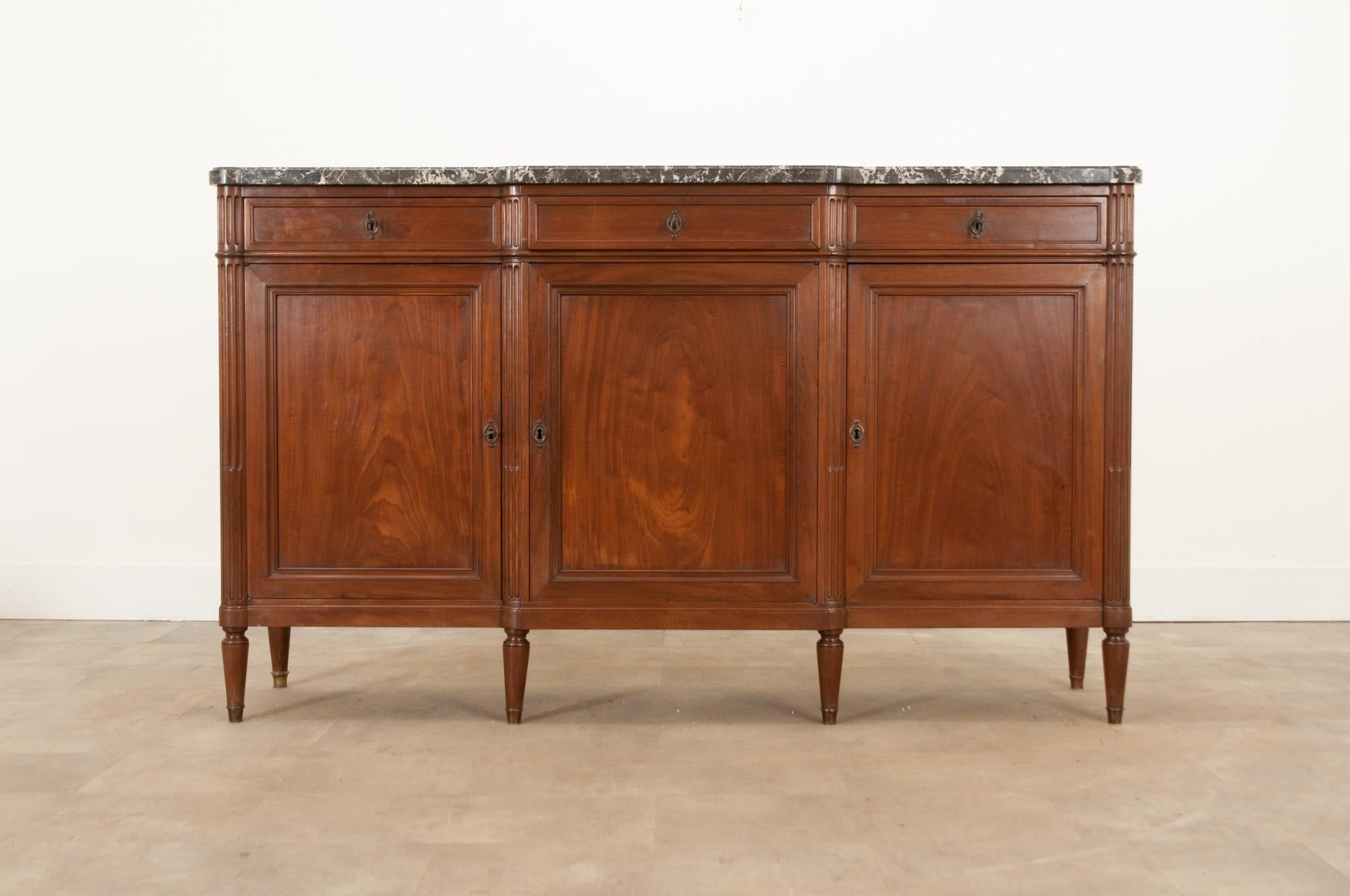 A handsome Louis XVI style enfilade from France, crafted in the 1880s. The original shaped marble top is in wonderful condition and is removable. Three easy-to-use drawers with simple paneling and cast brass escutcheons, three keys serve as the