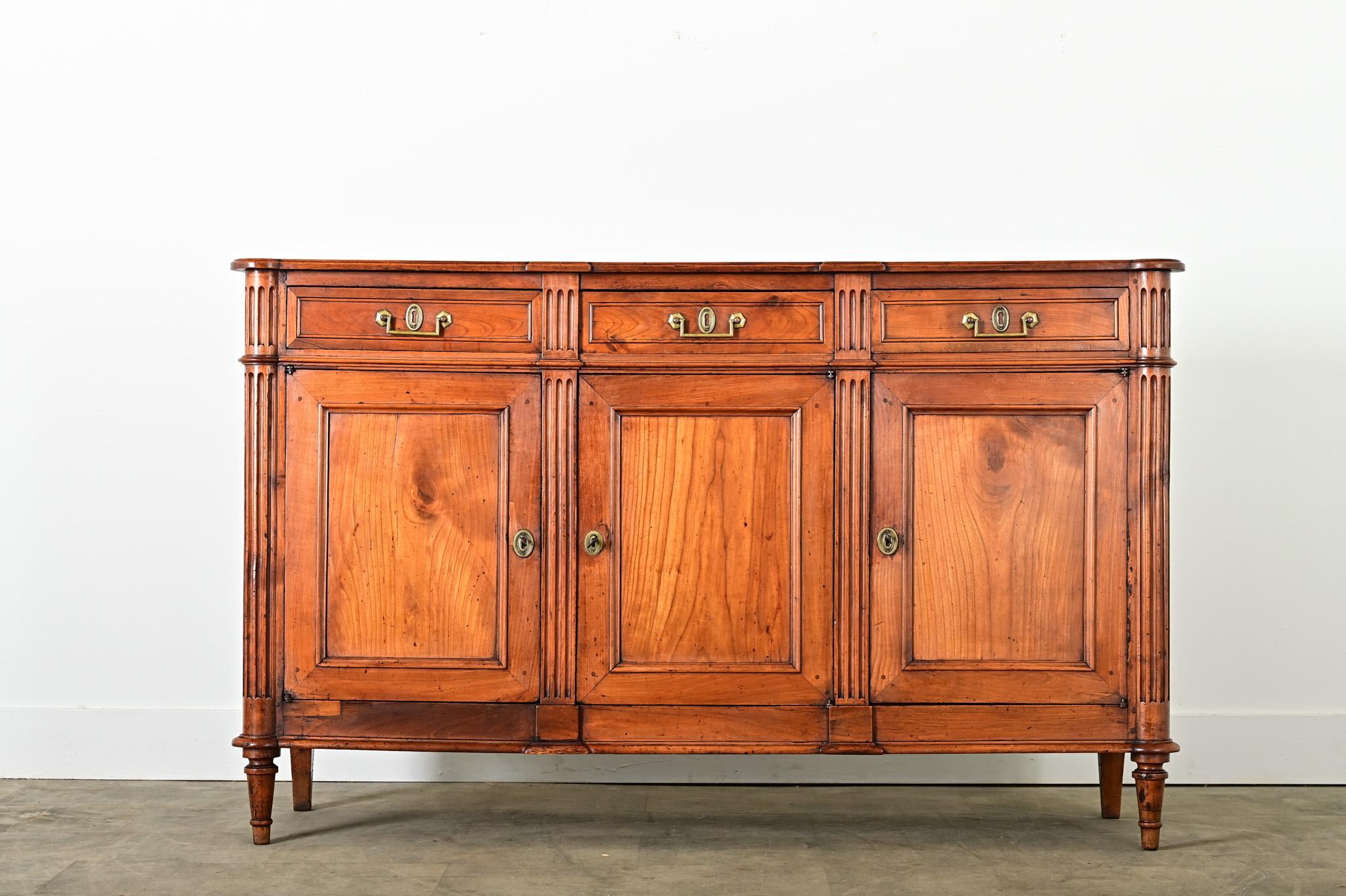 Esta enfilada de nogal estilo Luis XVI del siglo XIX, una pieza atemporal, aporta una presencia reconfortante a un comedor u otro espacio habitable con su cálido color y pátina. La superficie superior está rematada con esquinas torreadas y dos