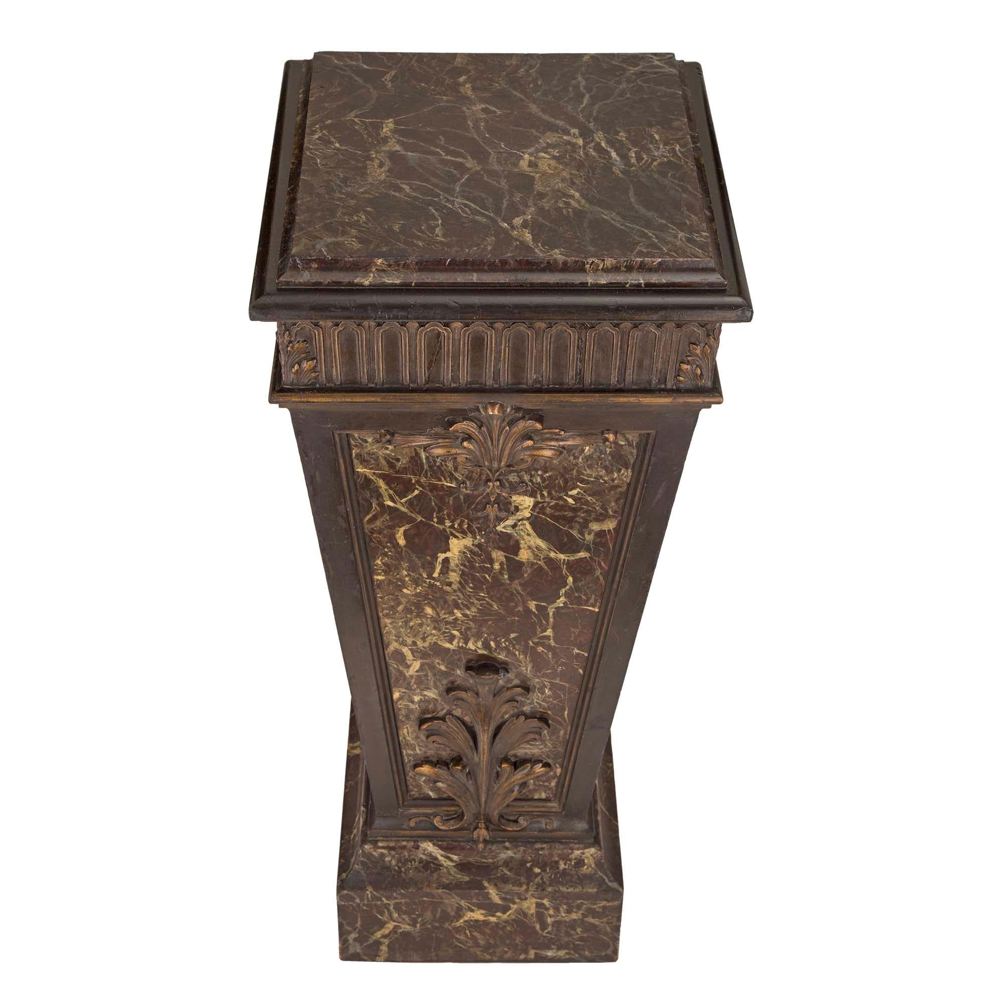 A very decorative French 19th century Louis XVI st. faux marble and patinated pedestal. The pedestal is raised on a square base below the tapered column. The pedestal has paneled sides with faux marble designs centered within patinated borders. At