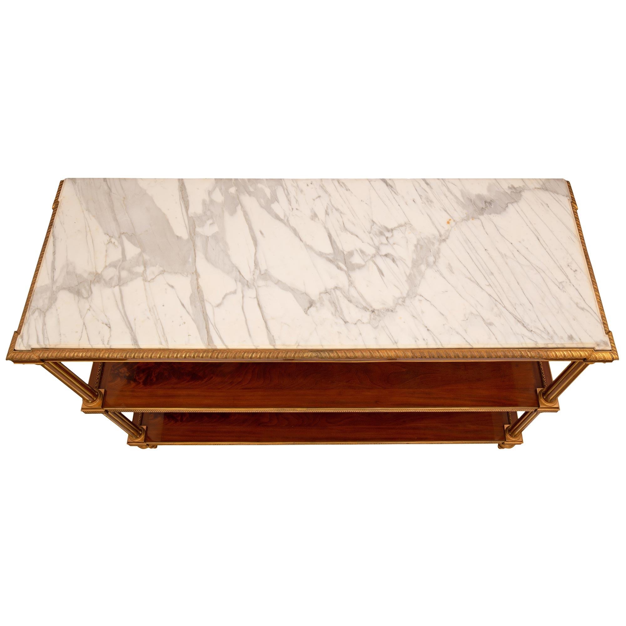 Una magnifica ed estremamente elegante consolle da dessert francese del XIX secolo in stile Luigi XVI in mogano fiammato e ormolu, attribuita a Beurdeley. La console di alta qualità è sollevata da quattro raffinati piedini in mogano a forma di topie