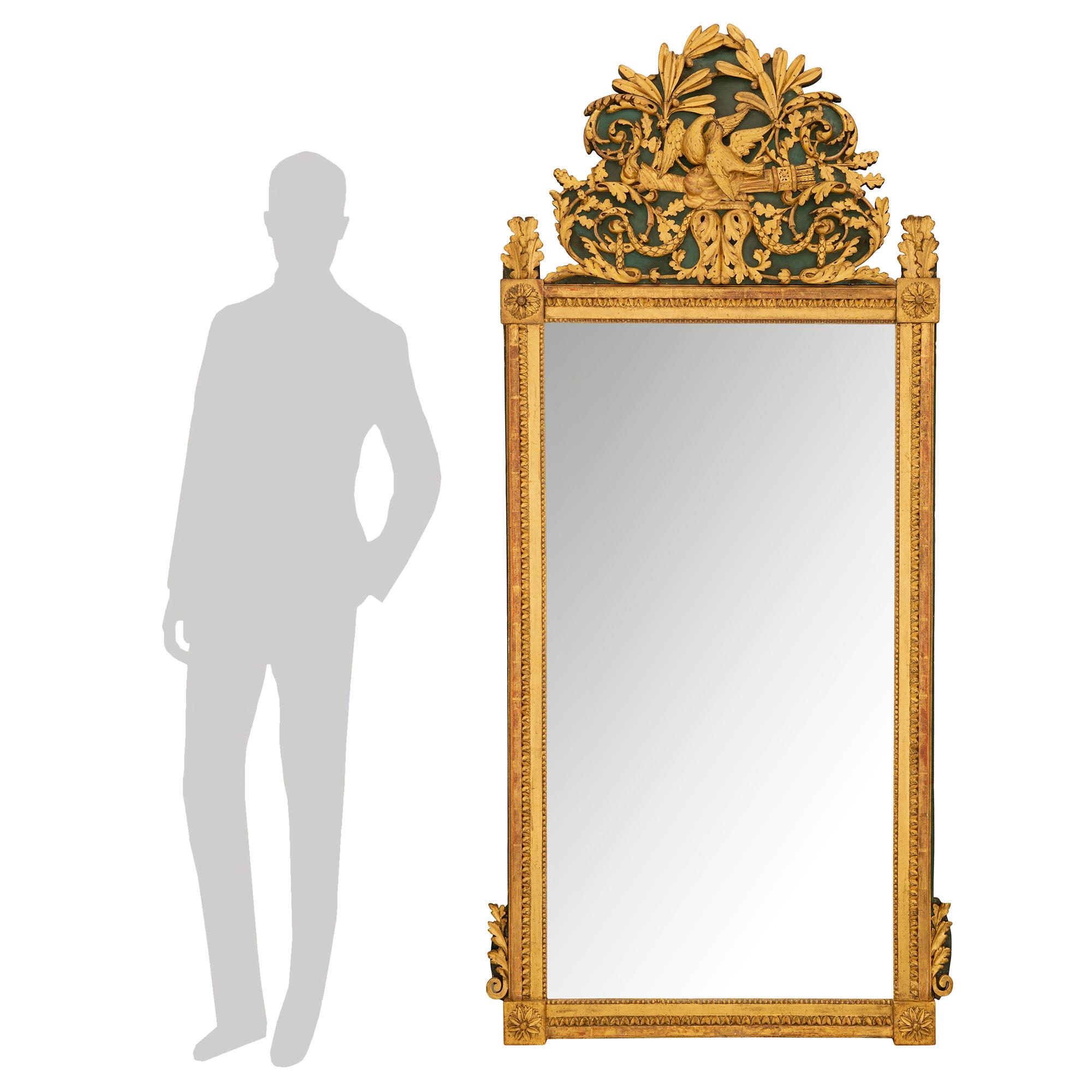 A most elegant and richly carved French 19th century Louis XVI st. giltwood and forest green mirror. The original mirror is framed within a finely detailed carved border with a lovely mottled and beaded design. Each corner displays a carved rosette