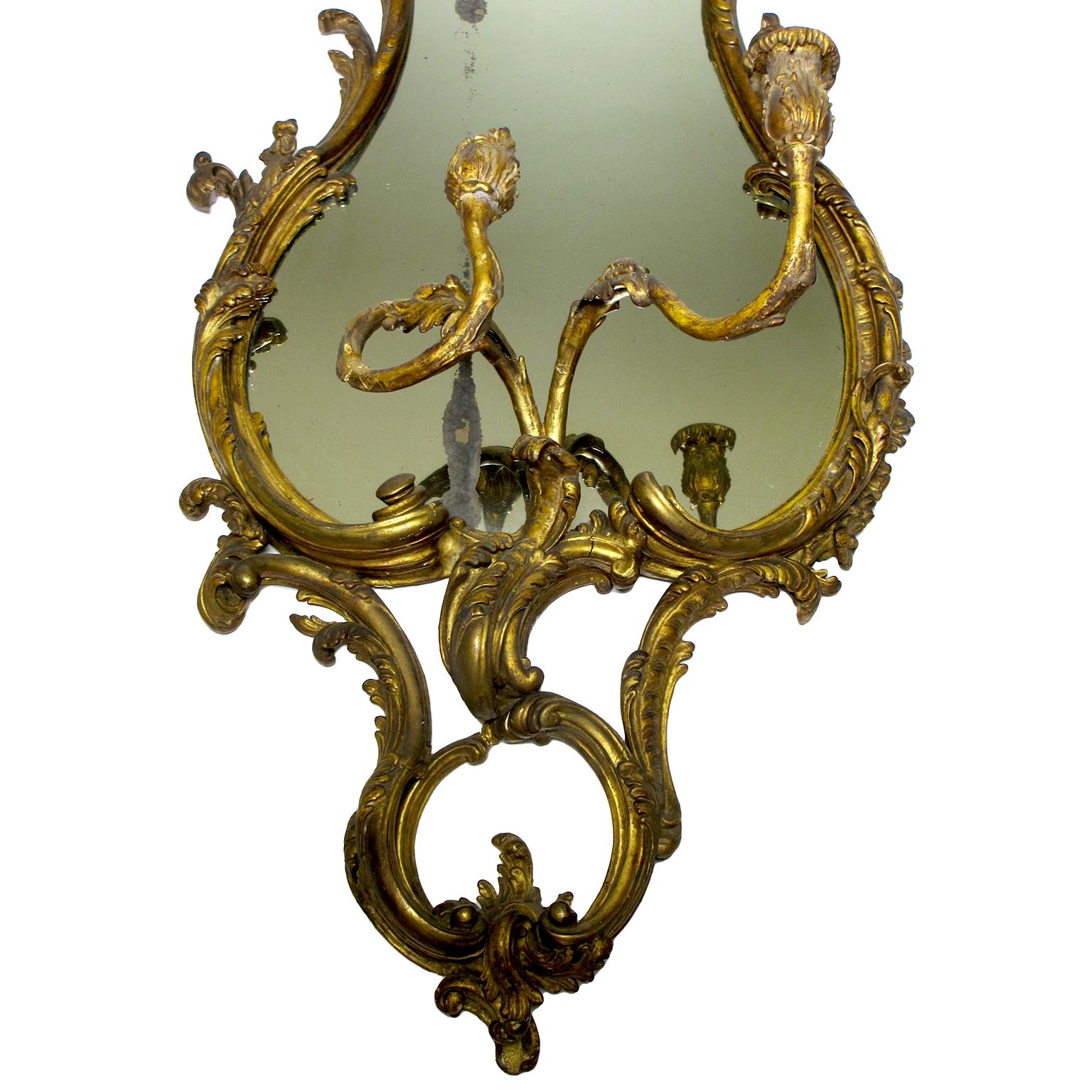 Un beau miroir girandole (lumière murale) de style Louis XVI du 19ème siècle en bois doré et gesso sculpté avec candélabre. Le cadre du miroir sculpté et à volutes est surmonté d'une paire de candélabres à volutes. Paris, 1880 environ.

Hauteur :