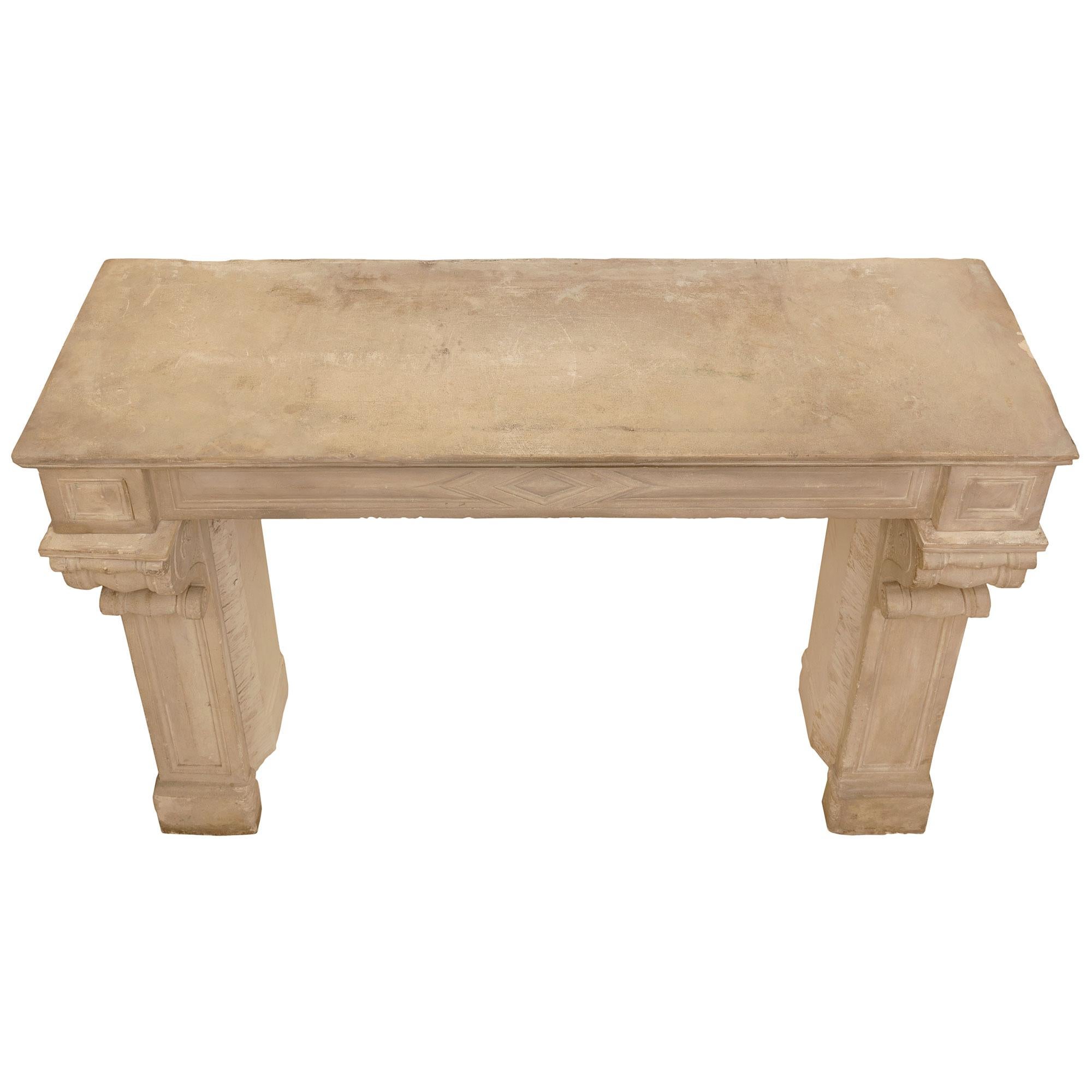 A most elegant French 19th century Louis XVI st. limestone mantel. The mantel is raised by fine block supports with elegant straight jambs, decorative mottled recessed panels and beautiful scrolled capital like movements. Above each jamb are