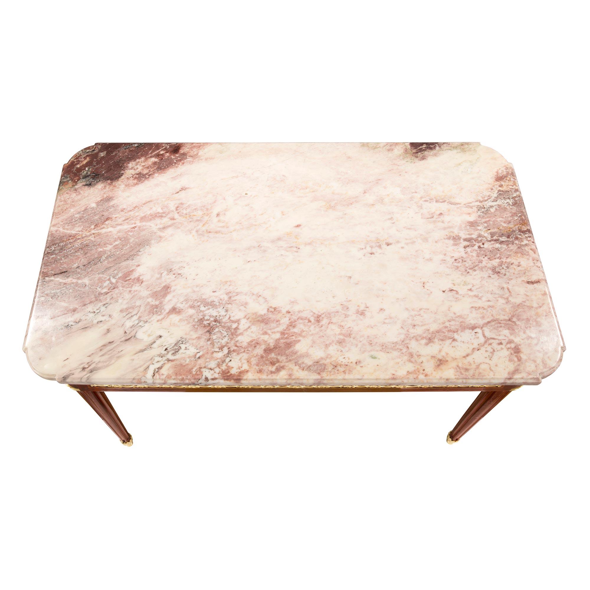 Ein sehr eleganter französischer rechteckiger Tisch aus Mahagoni und Ormolu aus der Mitte des 19. Jahrhunderts mit einer Platte aus Rosé Boréal-Marmor. Der Tisch steht auf vier kreisförmigen, konisch zulaufenden, kannelierten Beinen mit